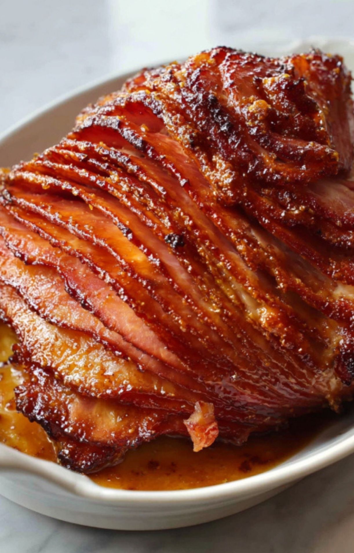 Spiral sliced smoked ham in baking dish with glaze, ready for oven reheating, juicy and moist for holiday meals