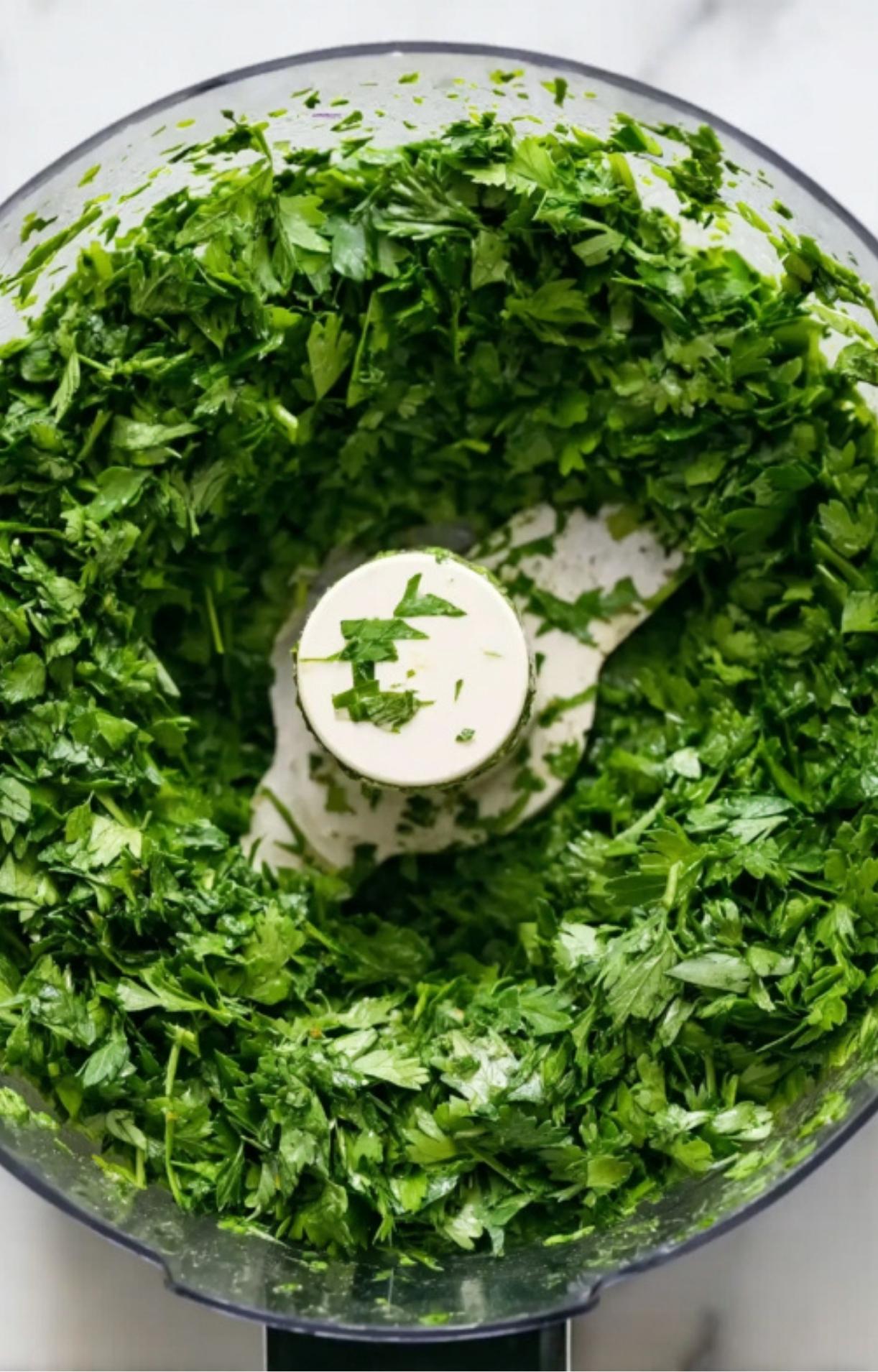 Fresh parsley chopped in a food processor, ready to use for homemade chimichurri sauce.
