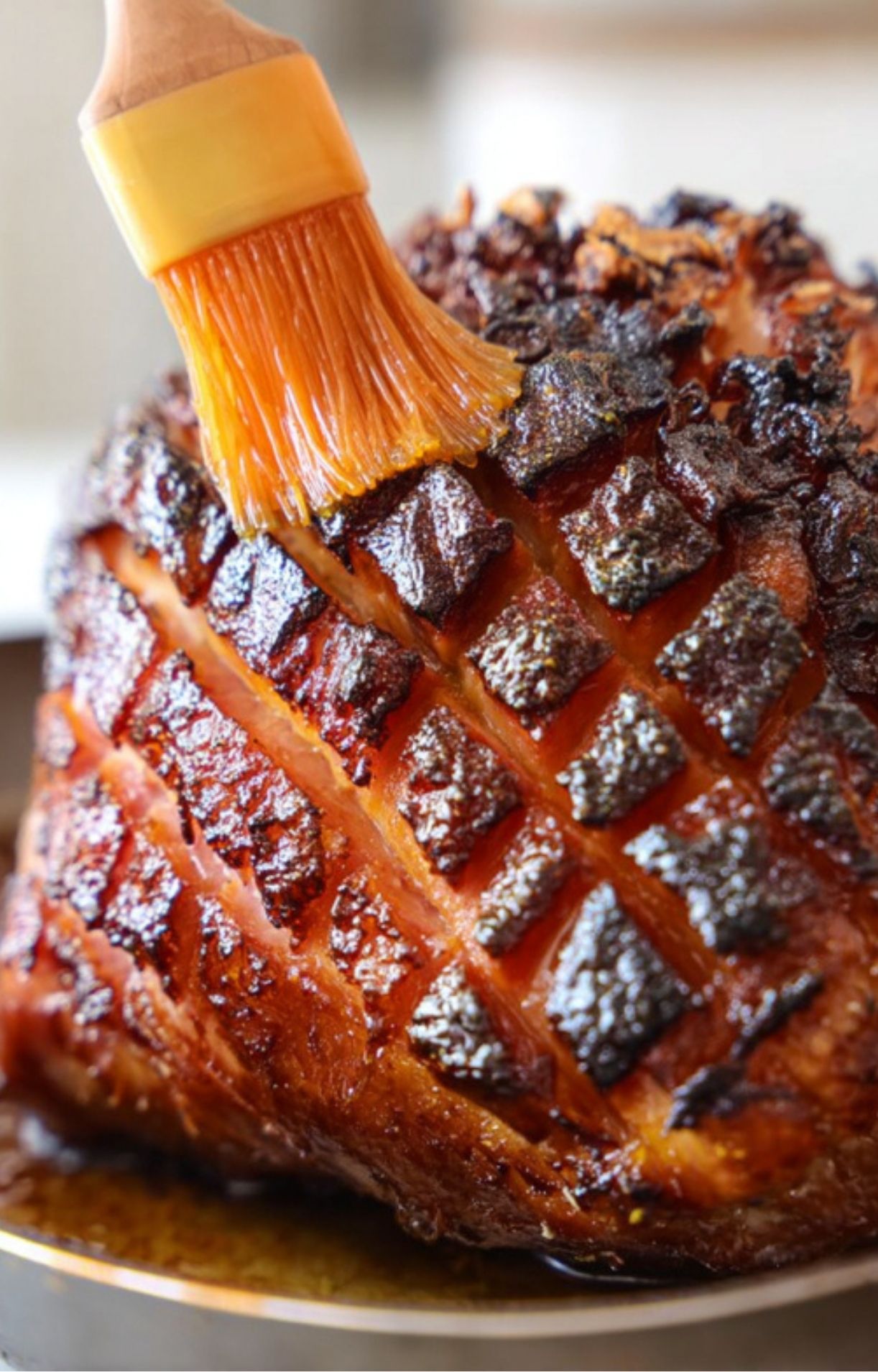 Brushing sweet glaze over smoked ham for extra flavor