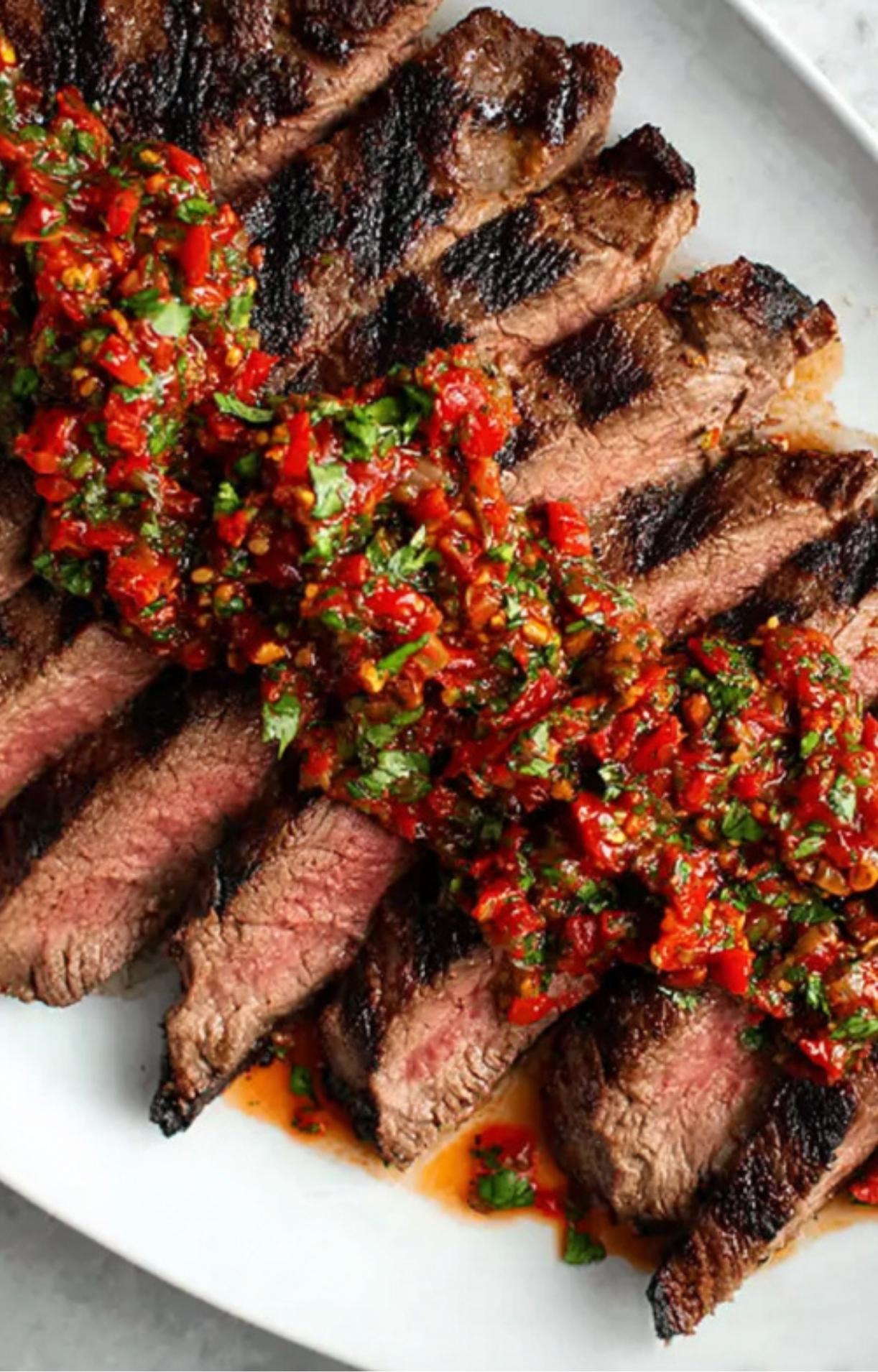 Grilled steak slices topped with a thick, spicy red chimichurri. Perfect for gluten free and high protein steak dinners.