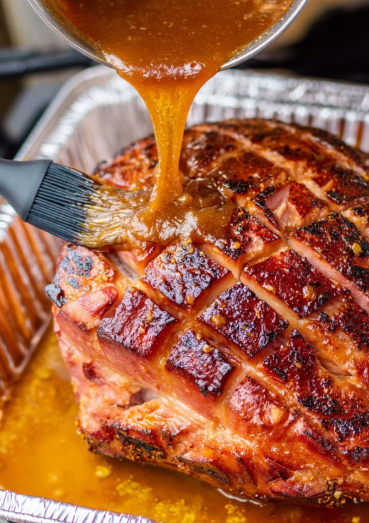 Brushing brown sugar glaze on twice smoked ham for holiday feast