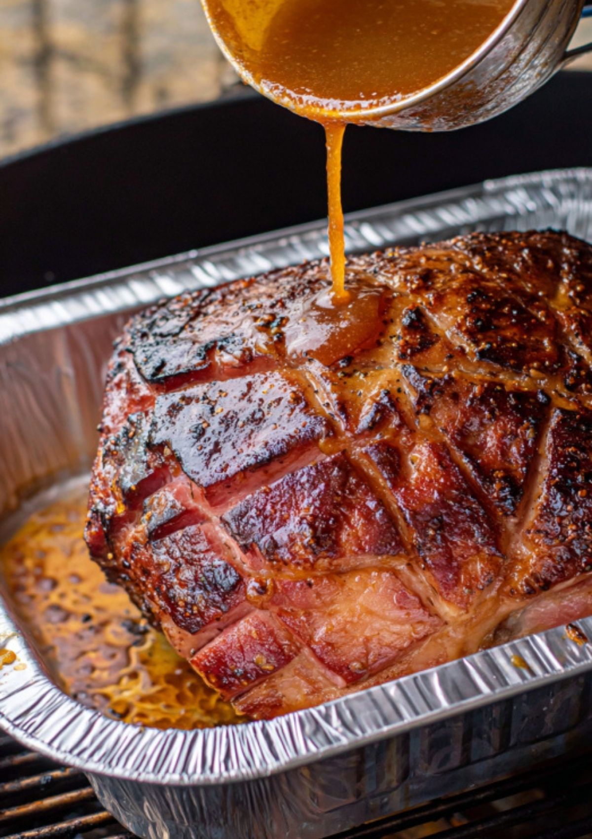 Pouring sweet glaze over smoked ham for Easter or Christmas meal