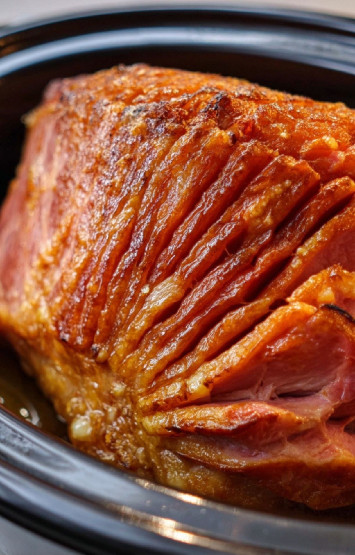 Fully glazed spiral ham in a slow cooker, golden brown and juicy for easy holiday meals.