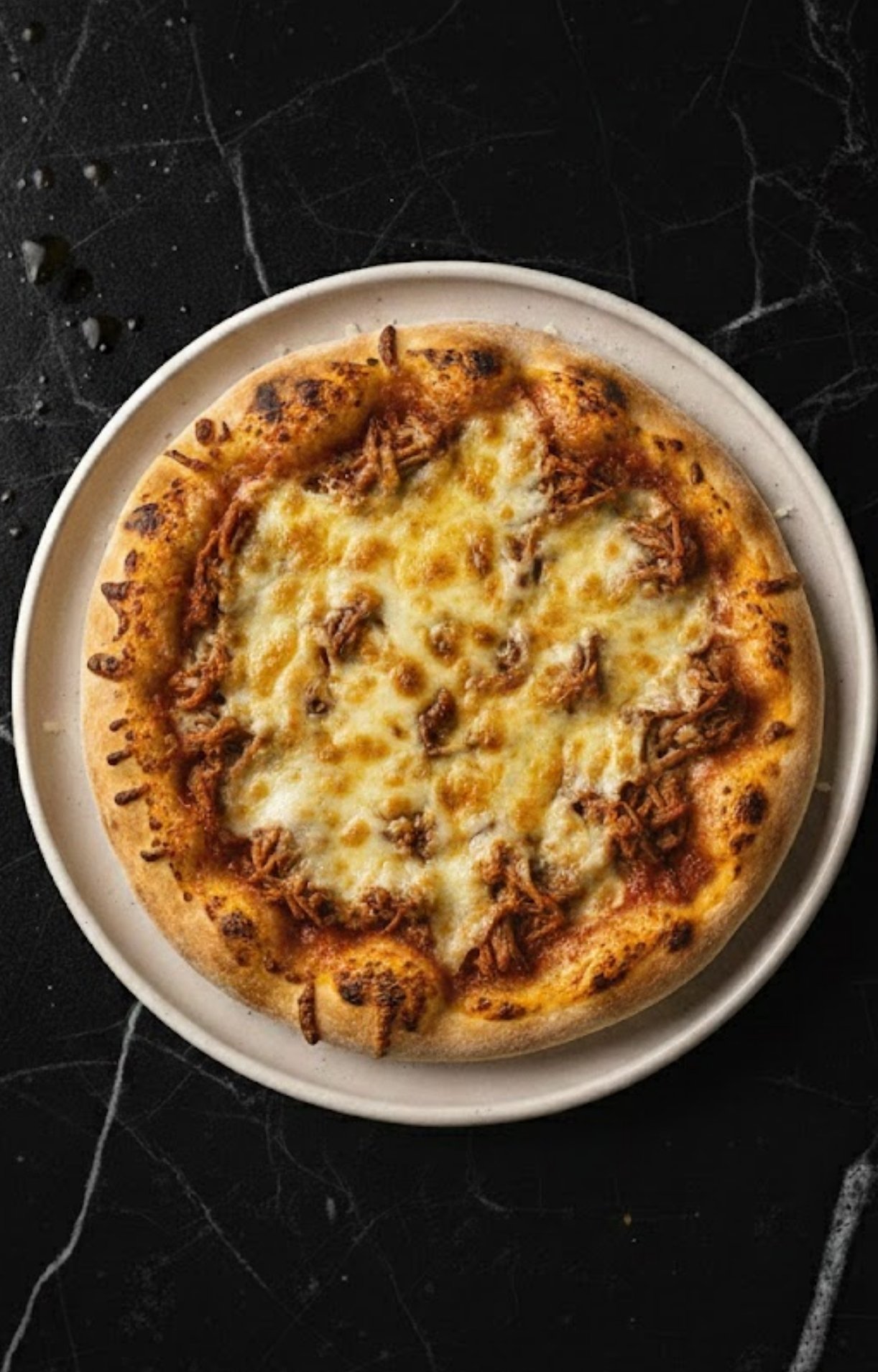 A golden-brown pizza straight from the oven with melted cheese and toasted crust edges.