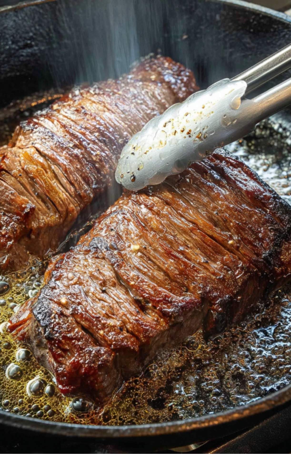 Flank steak sizzling in a cast iron skillet, ready to be topped with creamy avocado chimichurri sauce. High protein and keto-friendly.
