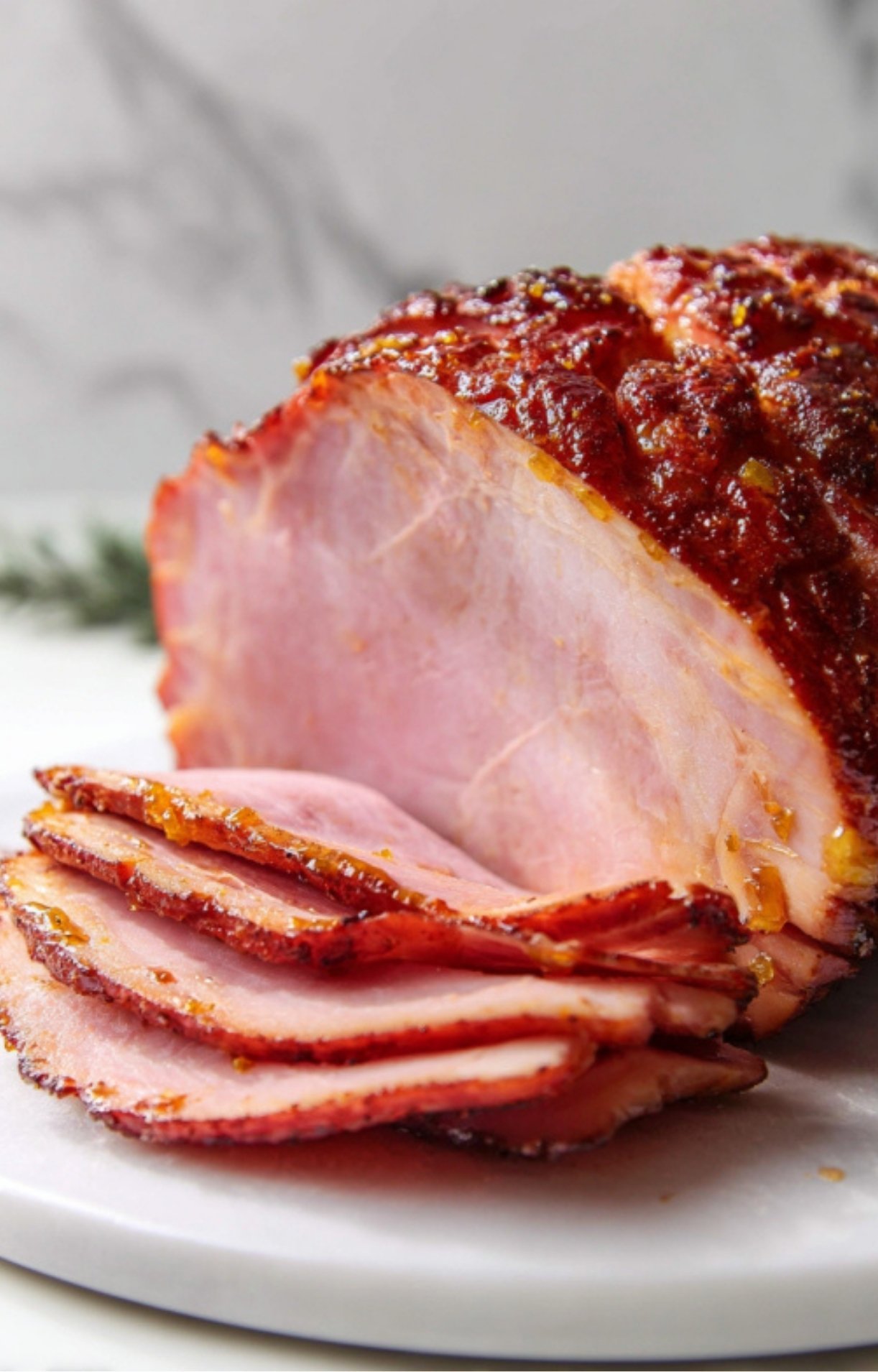 Juicy slices of smoked fresh ham on a white plate