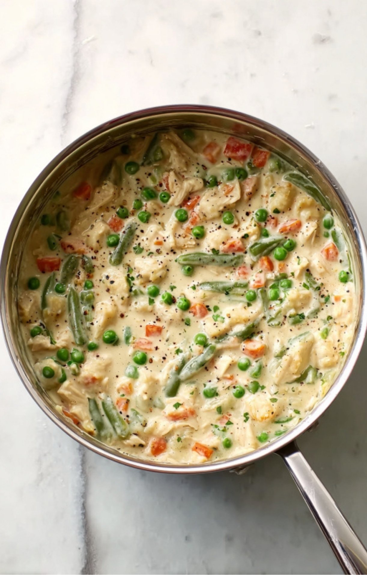 The completed filling for Dad’s Turkey Pot Pie, combining tender turkey and bright vegetables in a thick, herb-flecked cream sauce.