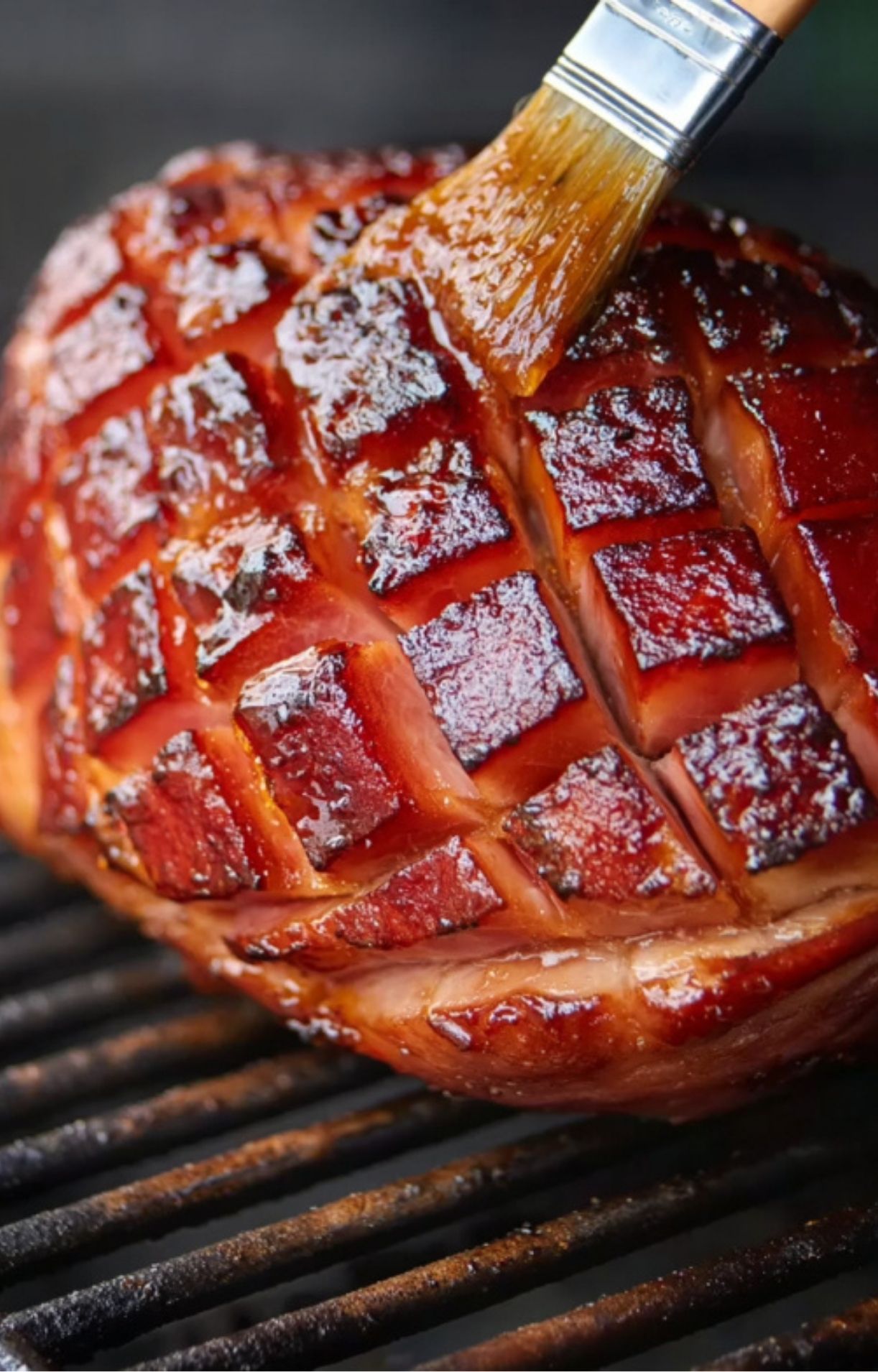 Sweet glaze brushed over caramelized smoked ham on the grill
