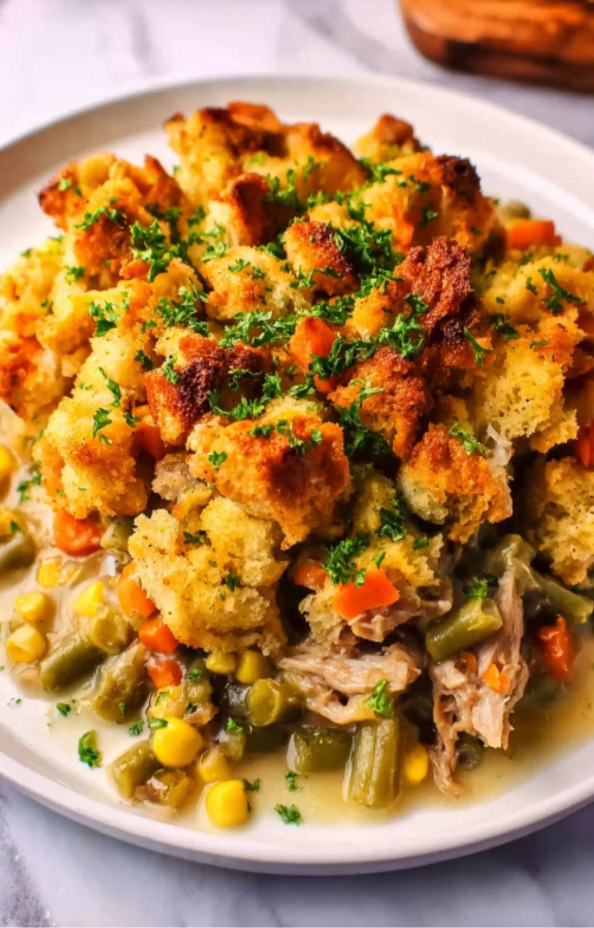 A high-angle shot of the plated recipe highlighting the textures of the shredded turkey, vibrant vegetables, and crunchy bread topping.