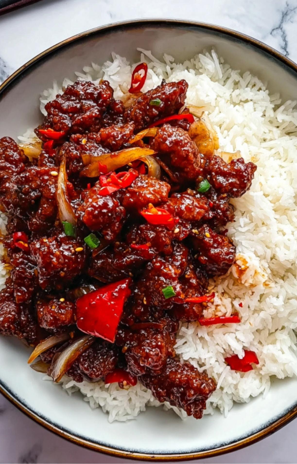 A close-up shot of crispy Beijing beef with red peppers and onions served over a bed of fluffy white rice in a ceramic bowl.