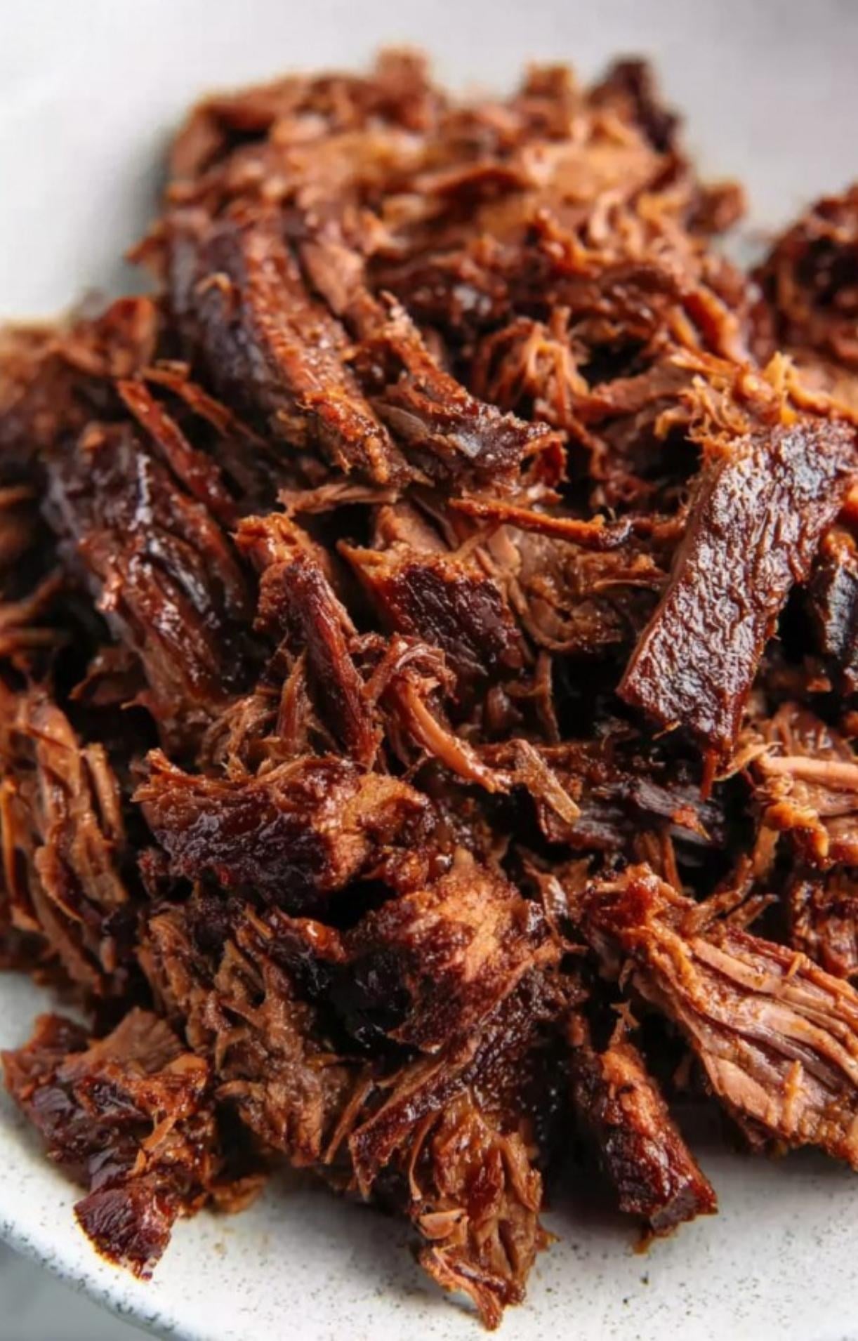 A pile of tender, hand-shredded smoked beef brisket ready to be used as a taco filling.
