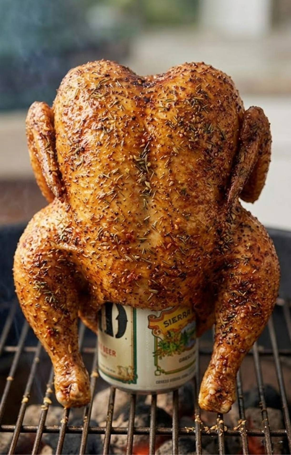 Up-close view of the seasoned chicken skin developing a crispy, golden-brown texture on the grill.