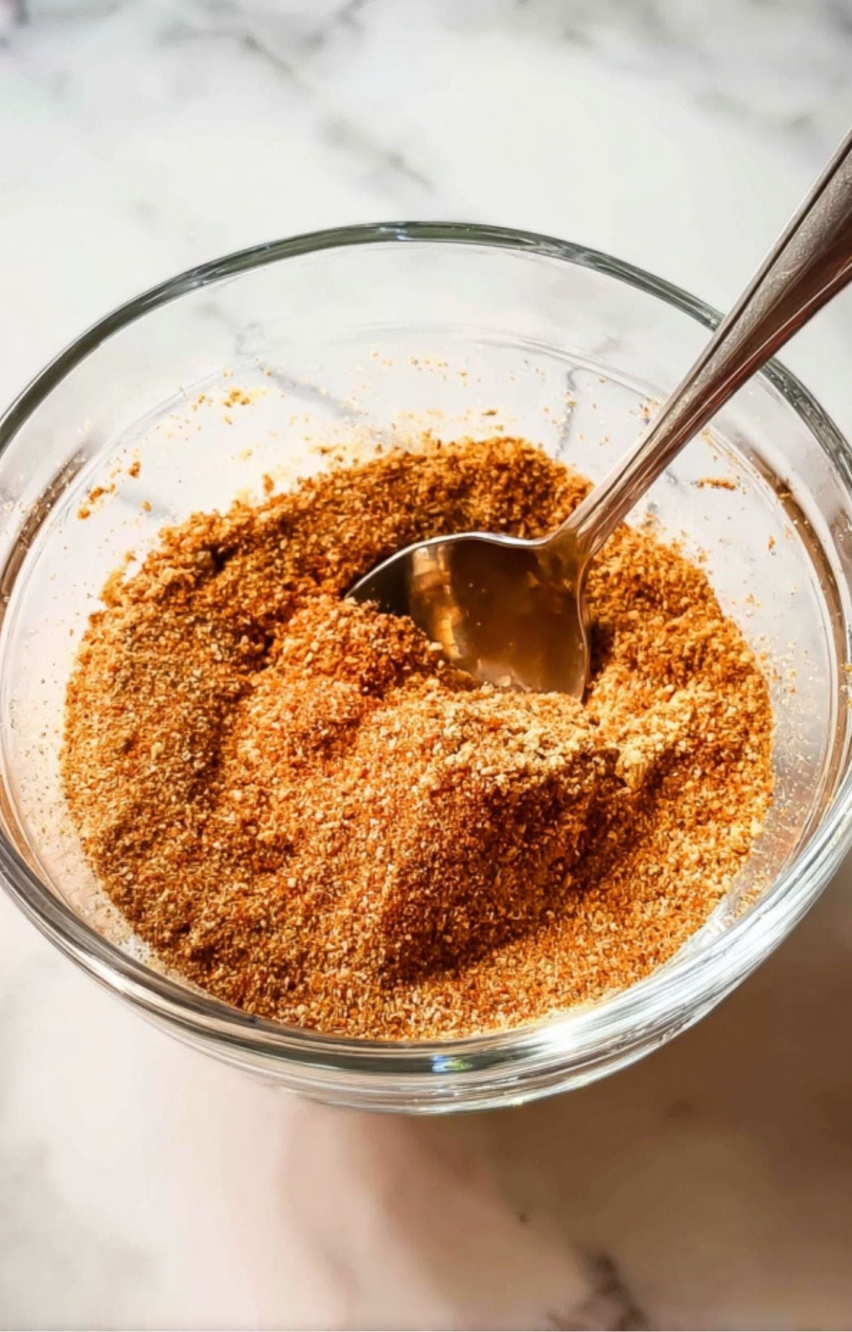 A glass bowl containing a blended dry rub of paprika, brown sugar, and garlic powder for Electric Smoker Beef Brisket.