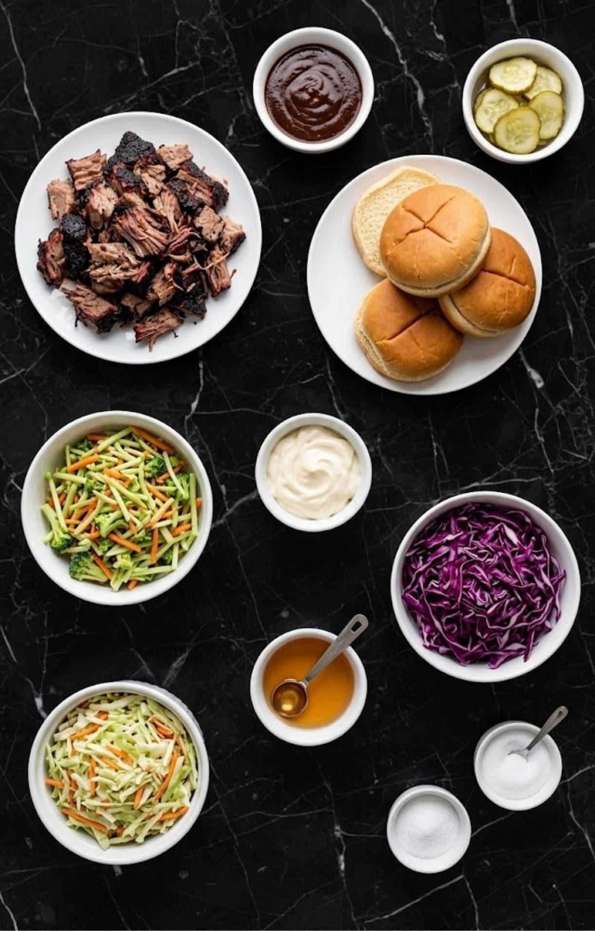An overhead view of various ingredients including chopped smoked brisket, brioche buns, barbecue sauce, pickles, and several bowls containing the elements for a fresh coleslaw.