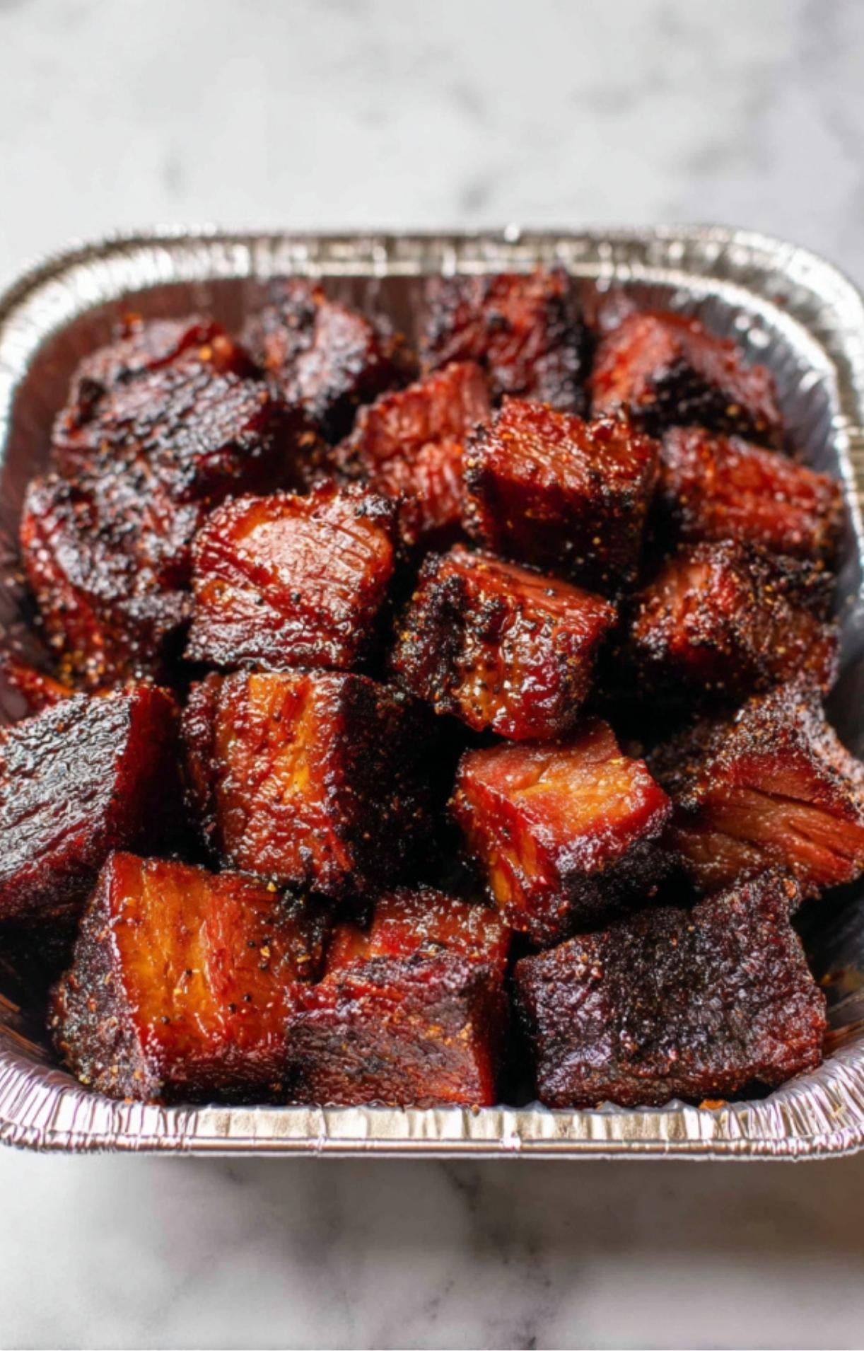 Freshly cut cubes of smoked beef showing the red smoke ring, ready to be glazed for Smoked Beef Brisket Burnt Ends.