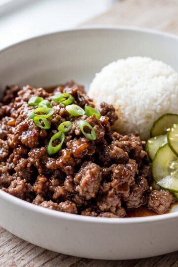wagyu ground beef recipe served in a bowl with white rice cucumber slices and green onions easy dinner idea