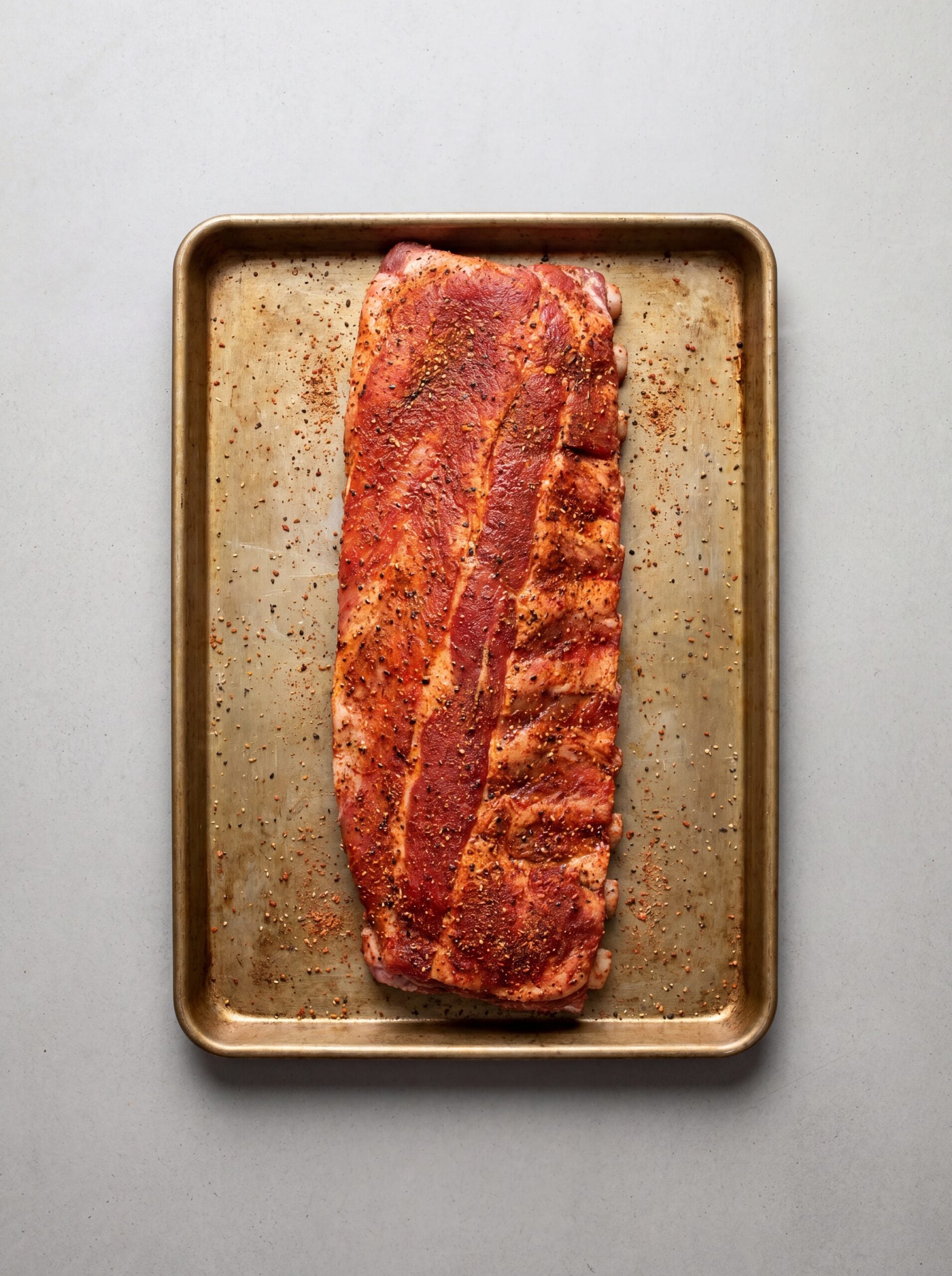 raw seasoned St Louis ribs on tray ready for pellet smoker