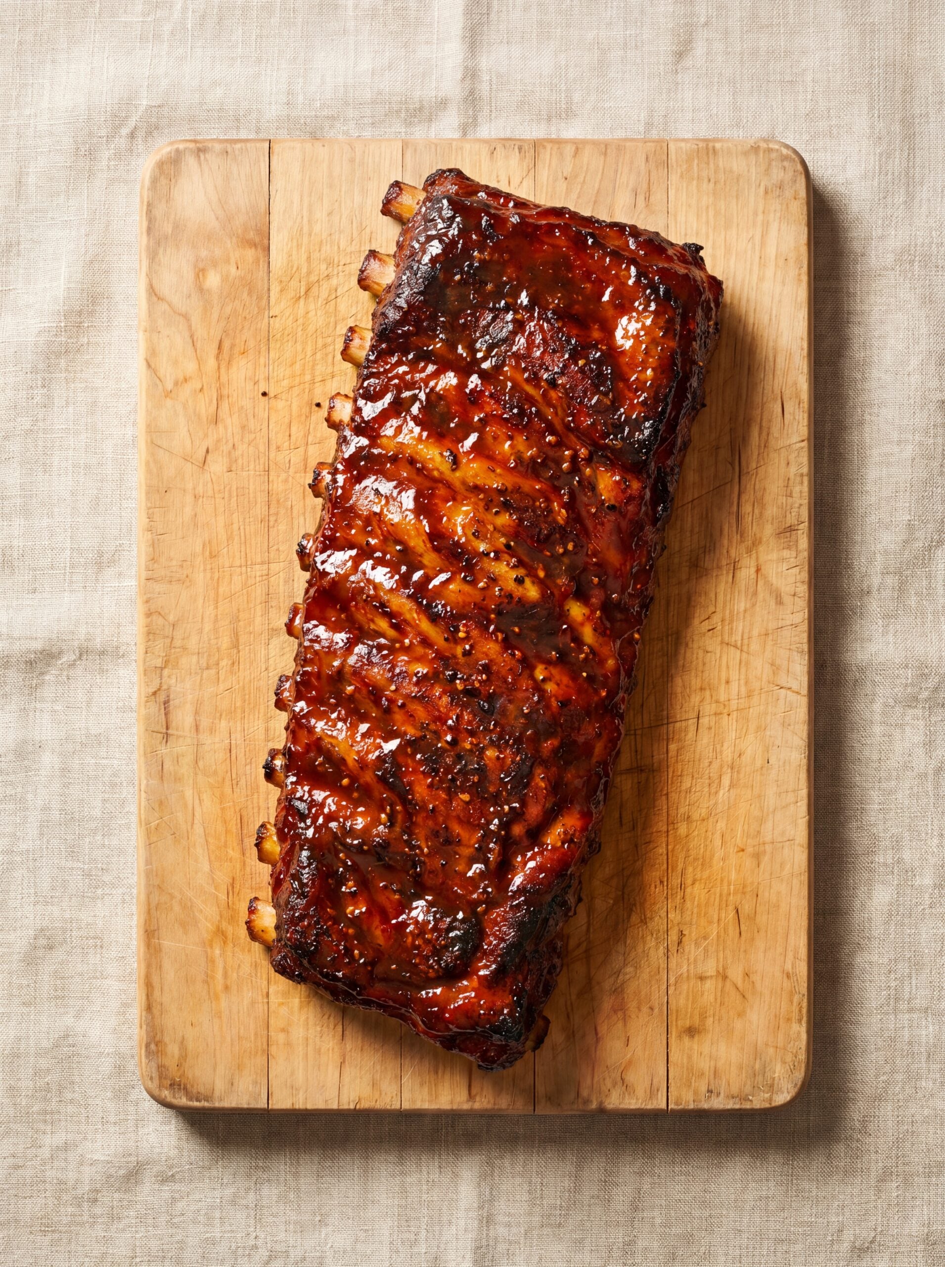 glazed St Louis ribs on wooden board with rich bbq sauce coating