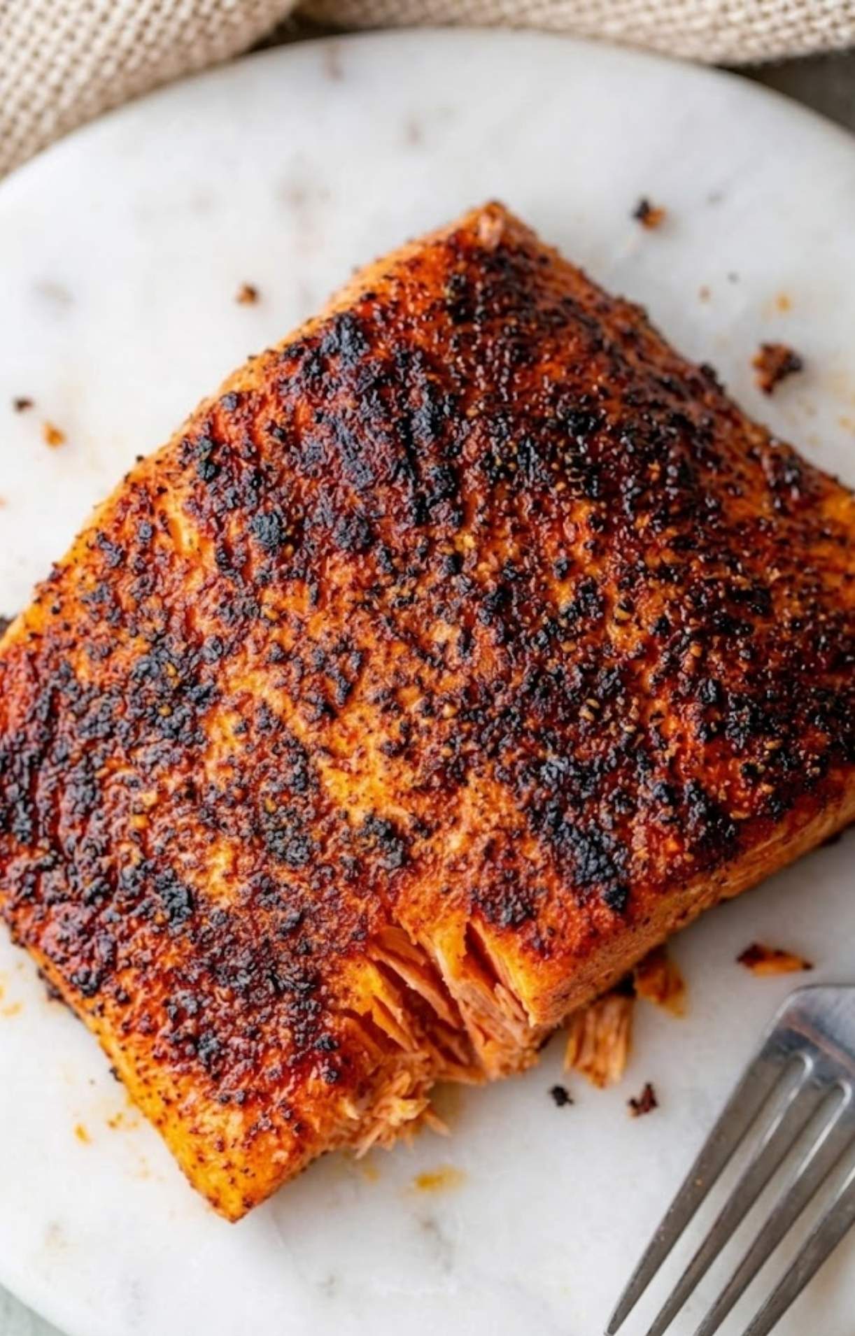A macro view of a sockeye salmon air fryer fillet highlighting the dark, caramelized spice rub and tender texture.