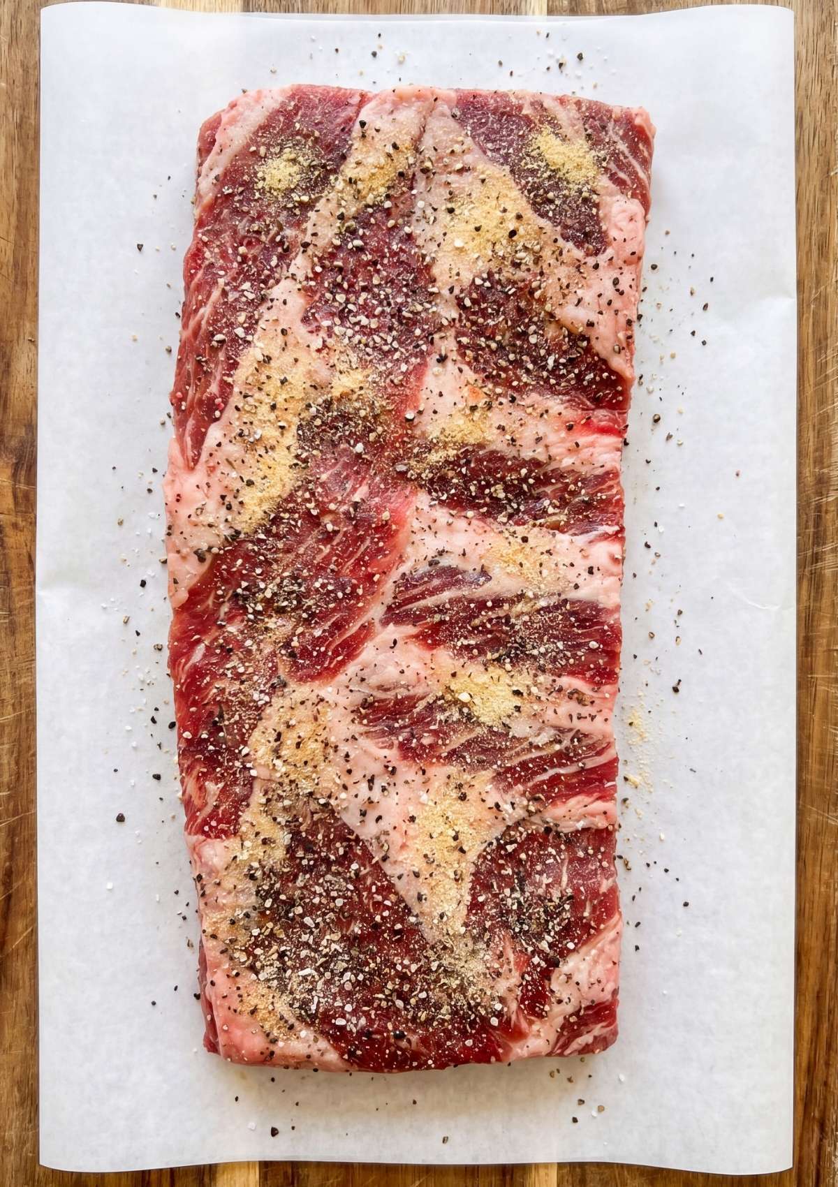 beef ribs pellet smoker recipe with raw ribs covered in salt pepper and garlic seasoning before smoking