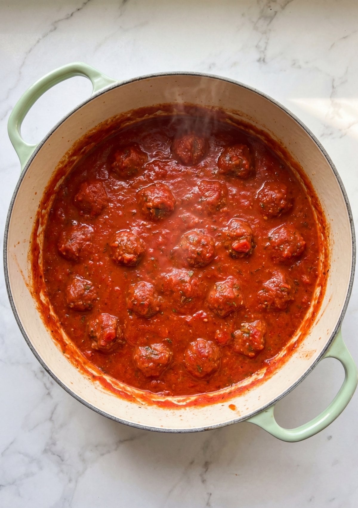 Wagyu beef meatballs simmering in rich tomato sauce in a pot easy homemade comfort food recipe