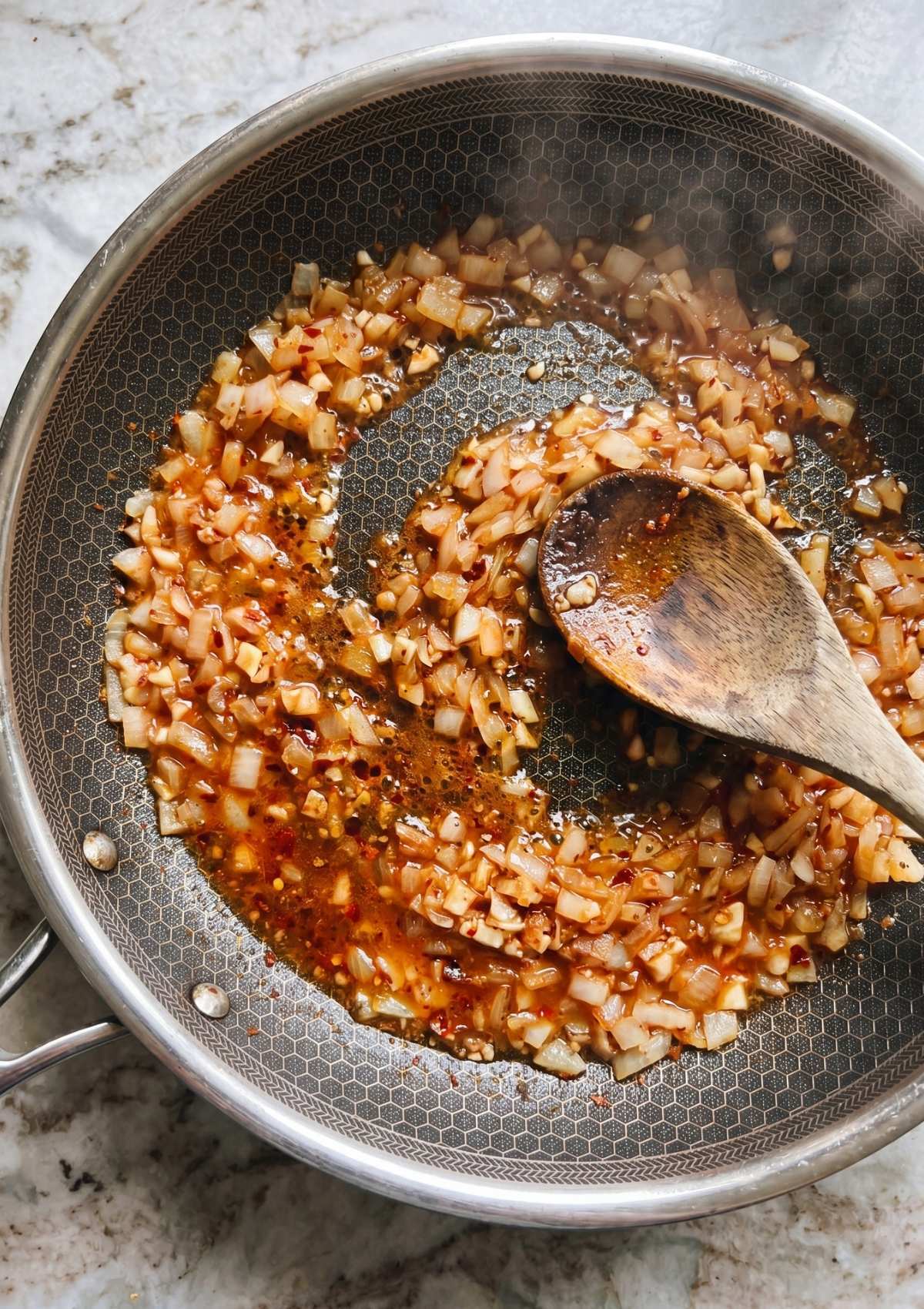 chopped onions and garlic cooking in butter for cowboy chicken spaghetti recipe base flavor