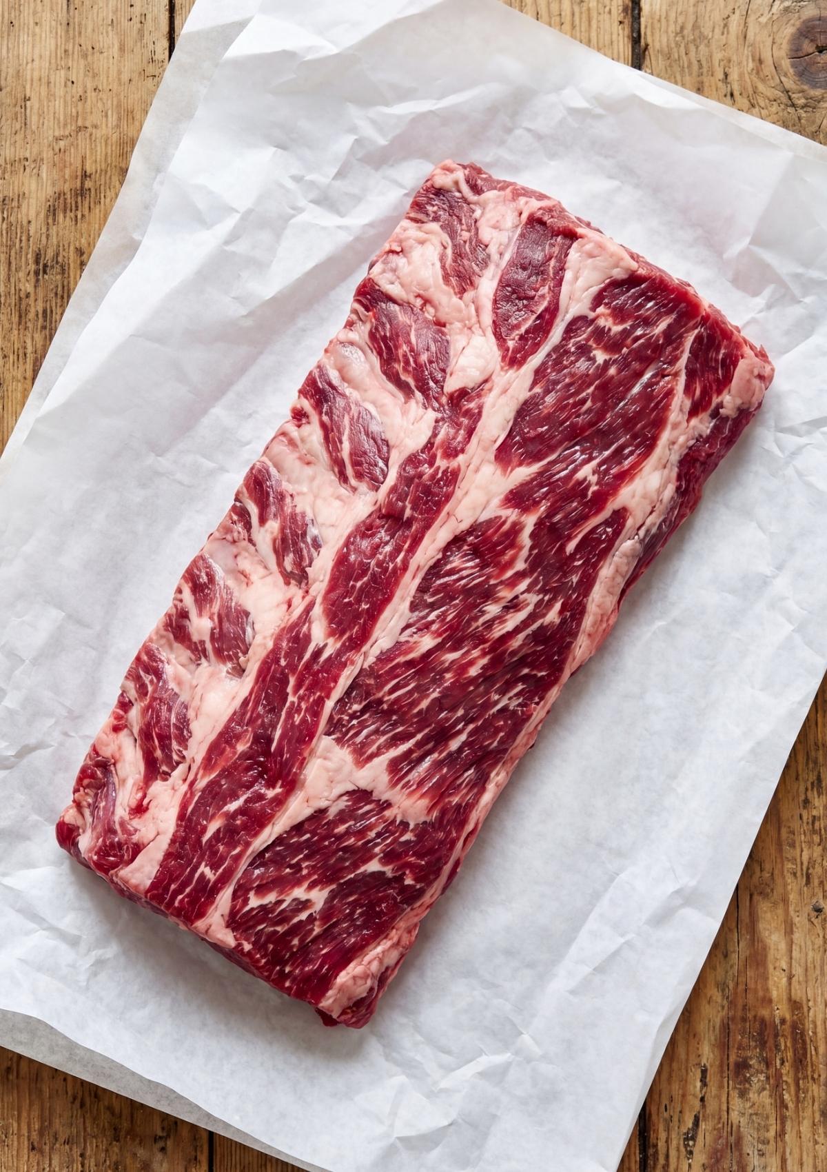 beef ribs pellet smoker recipe showing raw marbled beef ribs ready for smoker prep on parchment paper