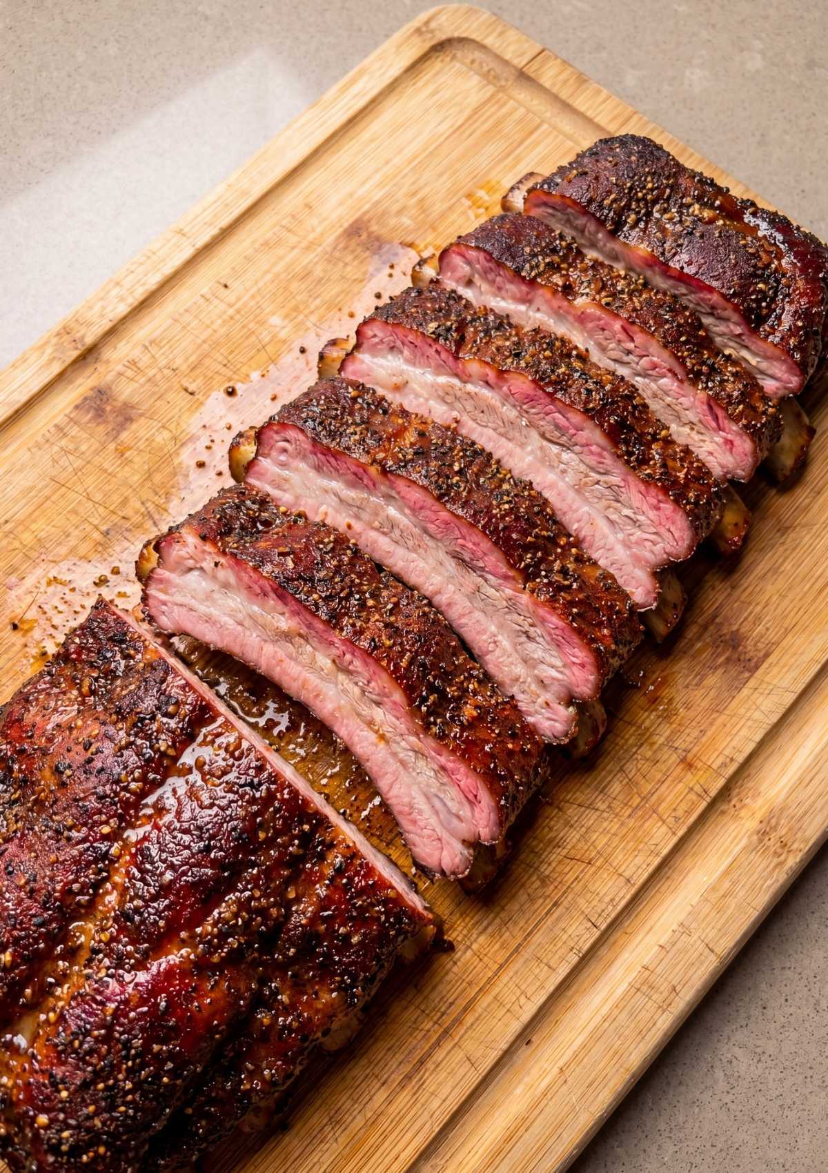 hands removing membrane from raw ribs for pellet smoker memphis ribs recipe preparation