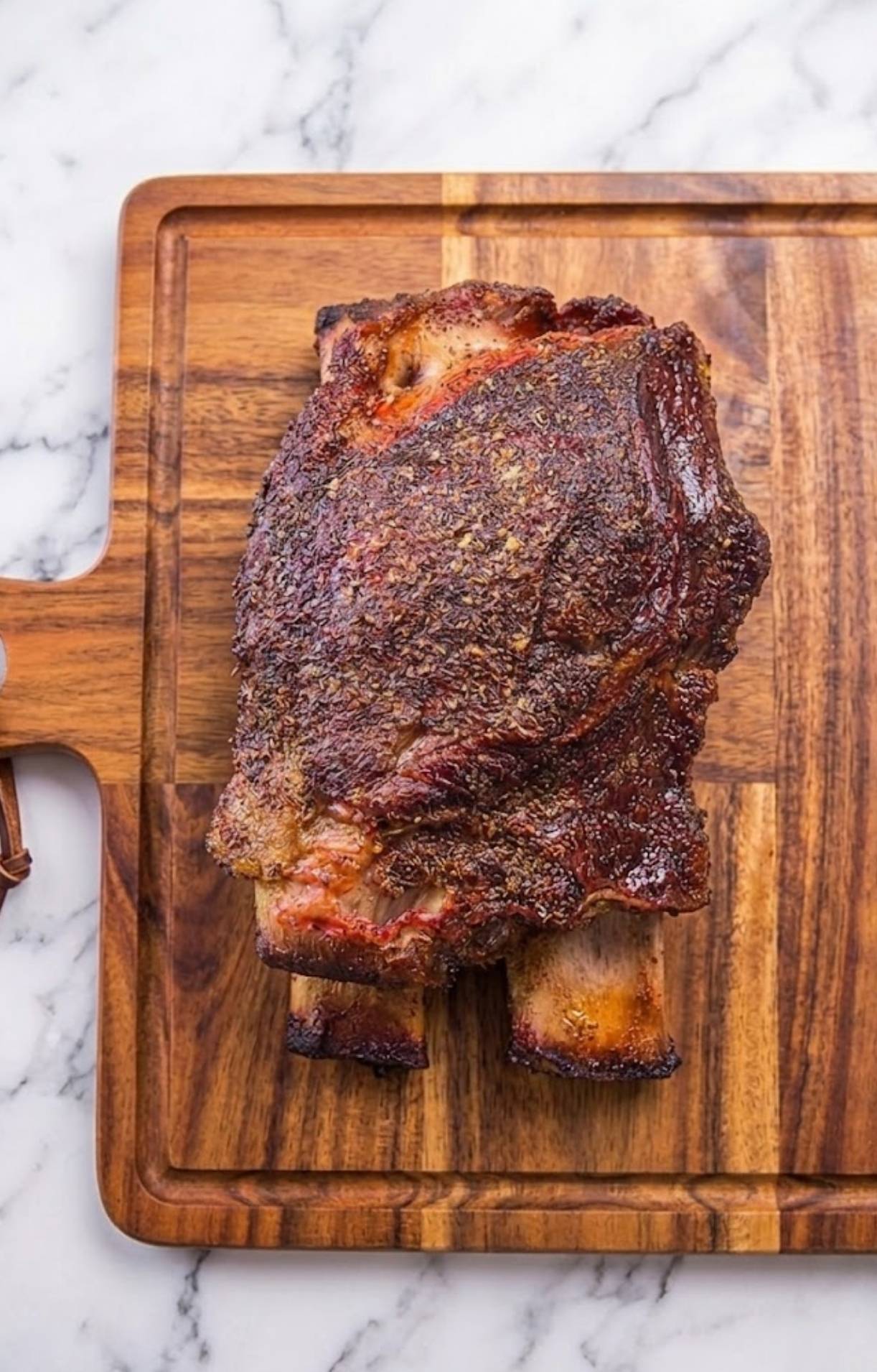 Whole smoked beef short ribs on wooden board with seasoning crust from pellet smoker
