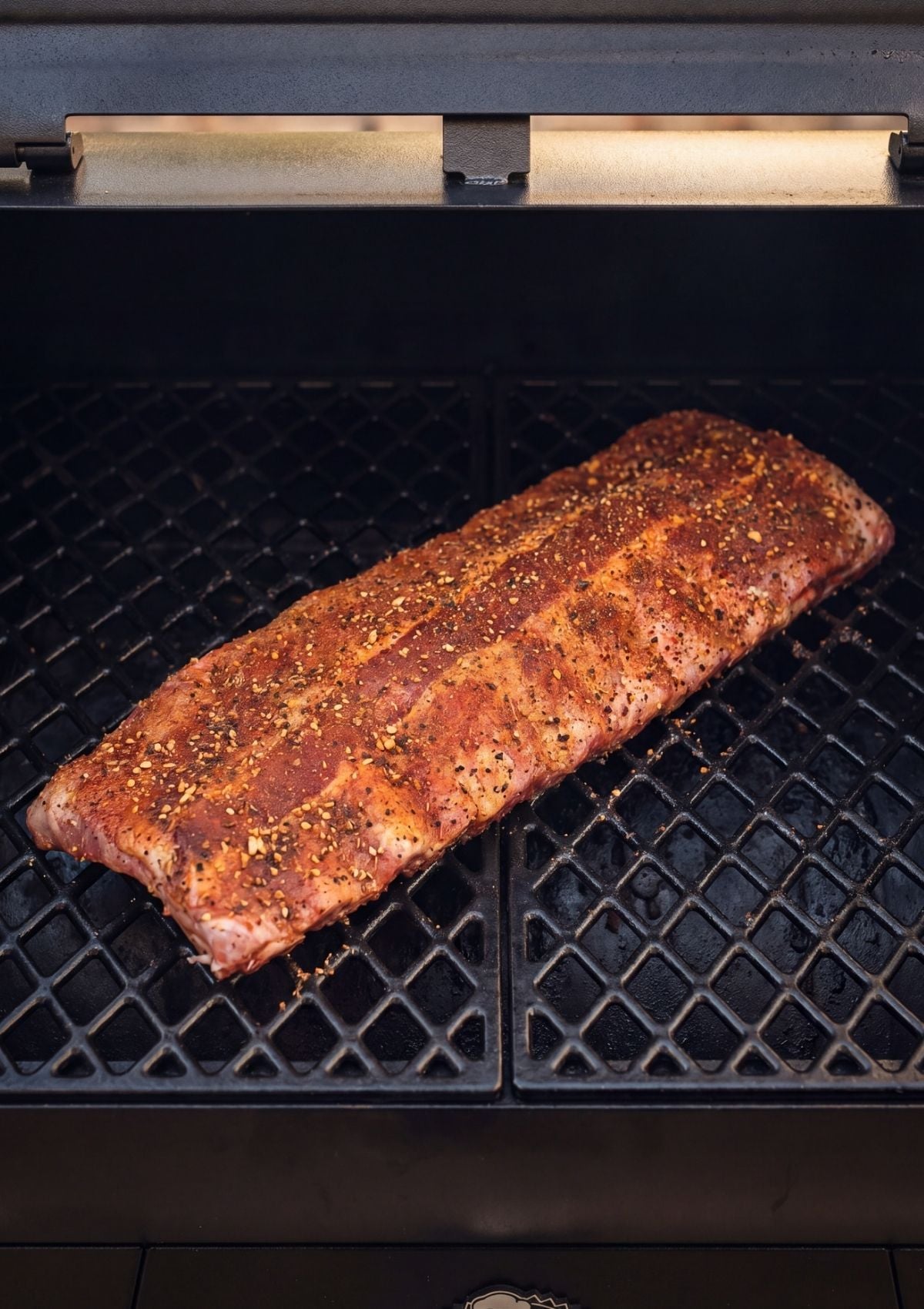 Pit Boss pellet smoker rib recipe with seasoned ribs cooking on pellet grill grates low and slow