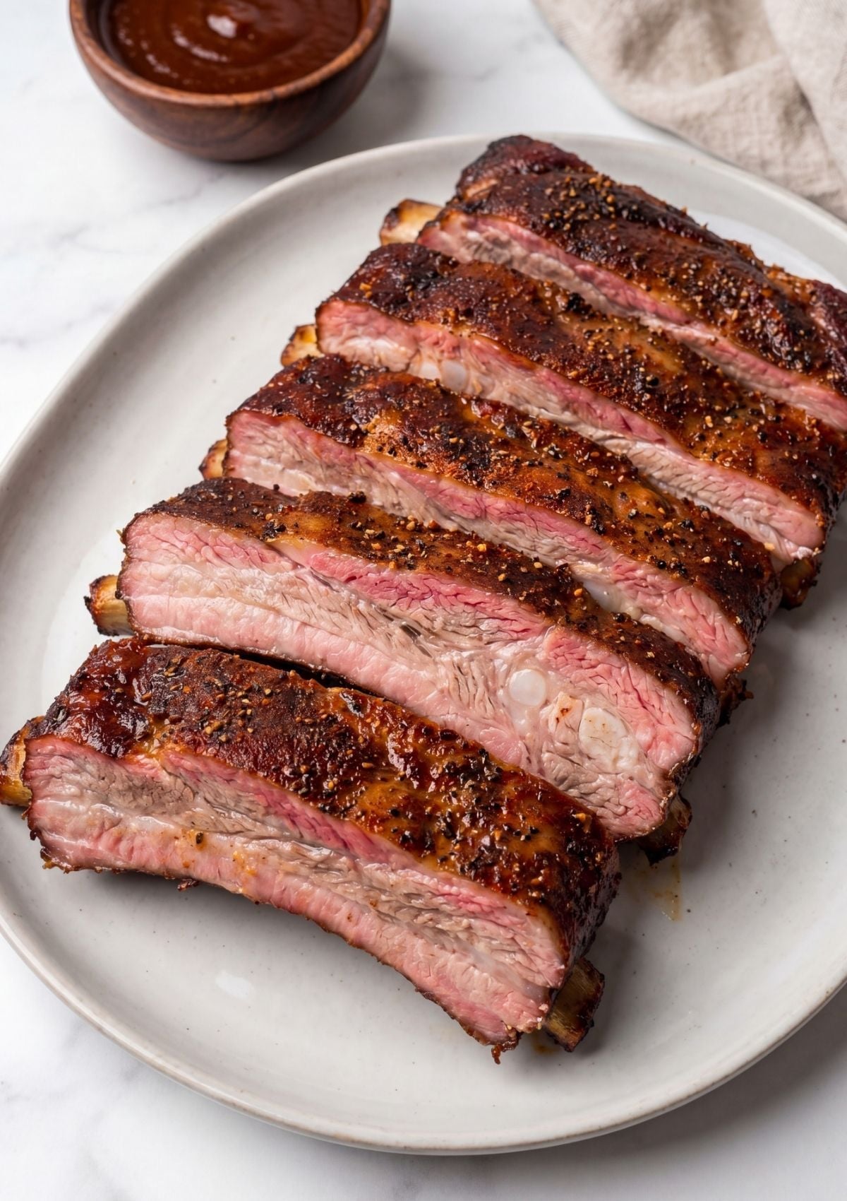 platter of smoked spare ribs with seasoning crust and smoky barbecue finish