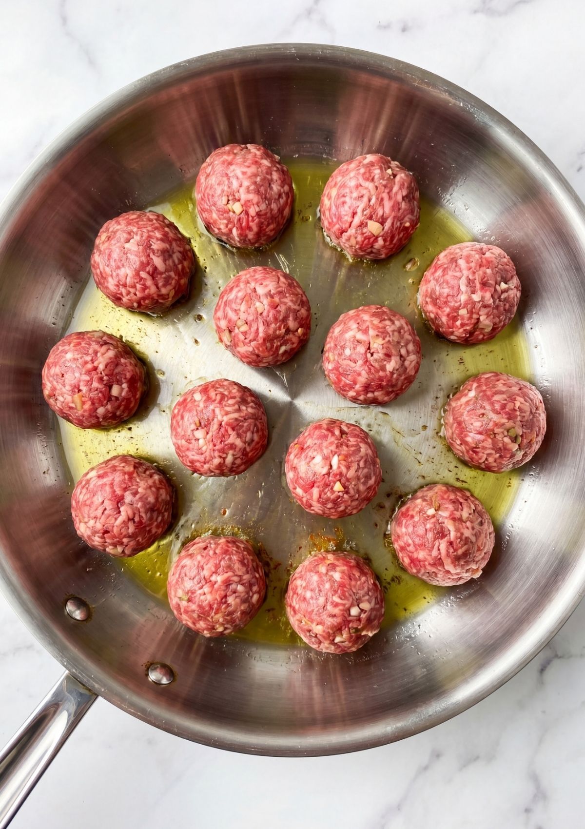 raw wagyu beef meatballs shaped in pan with olive oil easy prep step for homemade meatballs