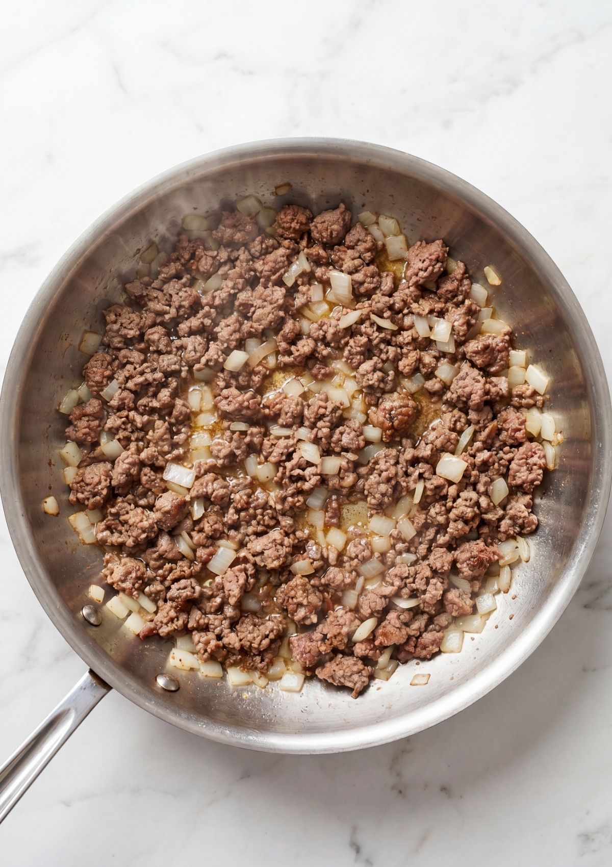 ground beef and onions cooking in pan for cowboy spaghetti with bacon easy one pot dinner
