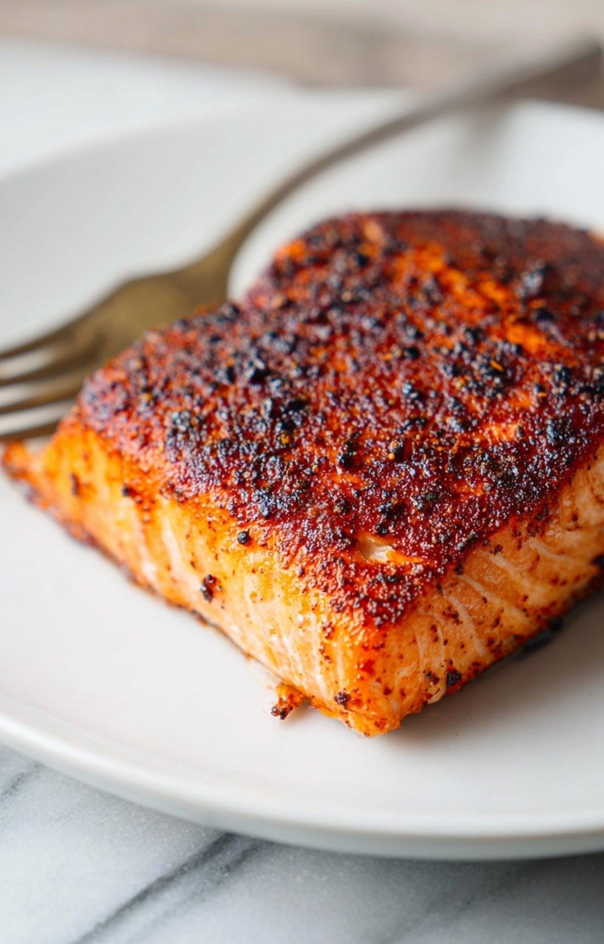 A side profile of a finished sockeye salmon air fryer portion with a beautiful spice crust and vibrant orange color.