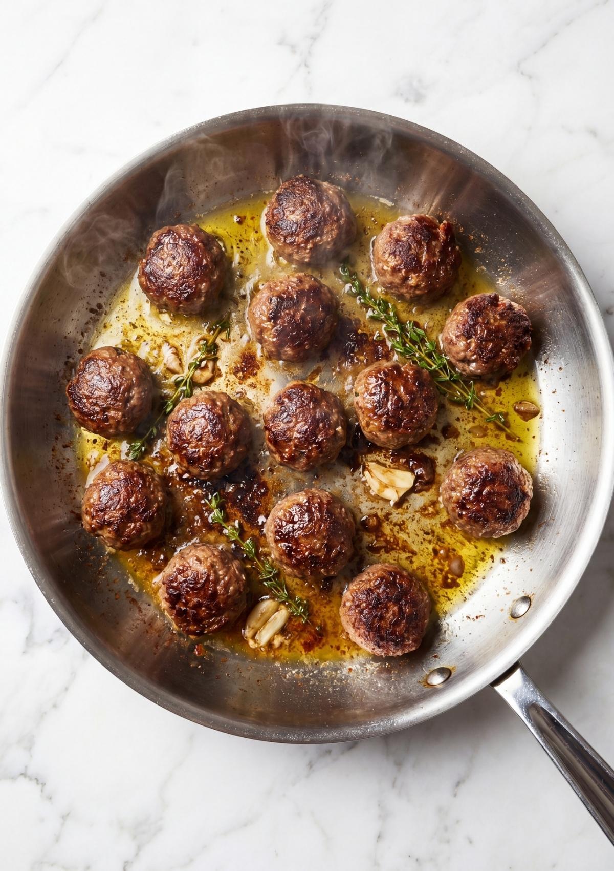 wagyu beef meatballs browning in skillet with garlic and herbs juicy seared meatballs recipe