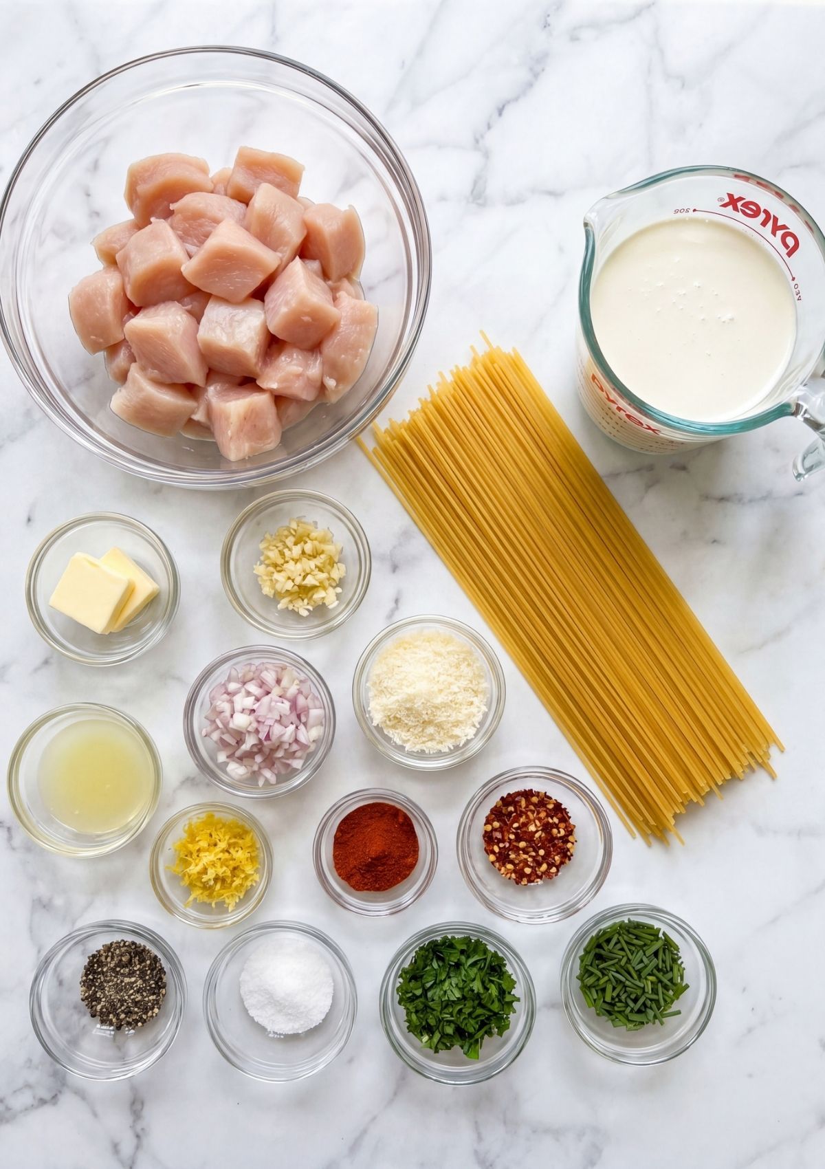 ingredients for cowboy chicken spaghetti including chicken pasta cream garlic spices and herbs