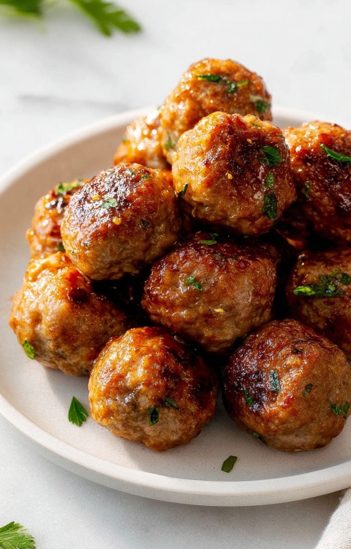 A pile of perfectly cooked turkey meatballs on a light-colored plate, highlighting the juicy interior and seared exterior.