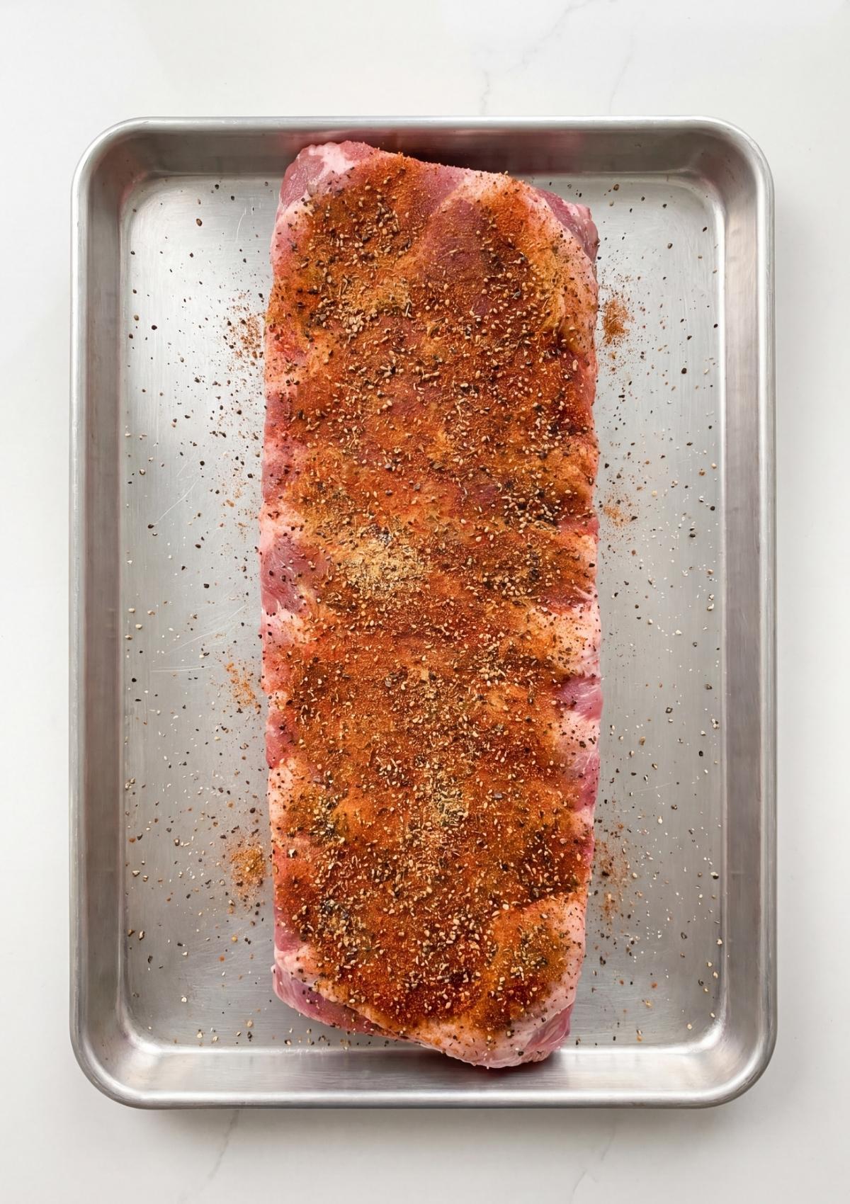 Pit Boss pellet smoker rib recipe with raw ribs covered in dry rub seasoning ready for smoking