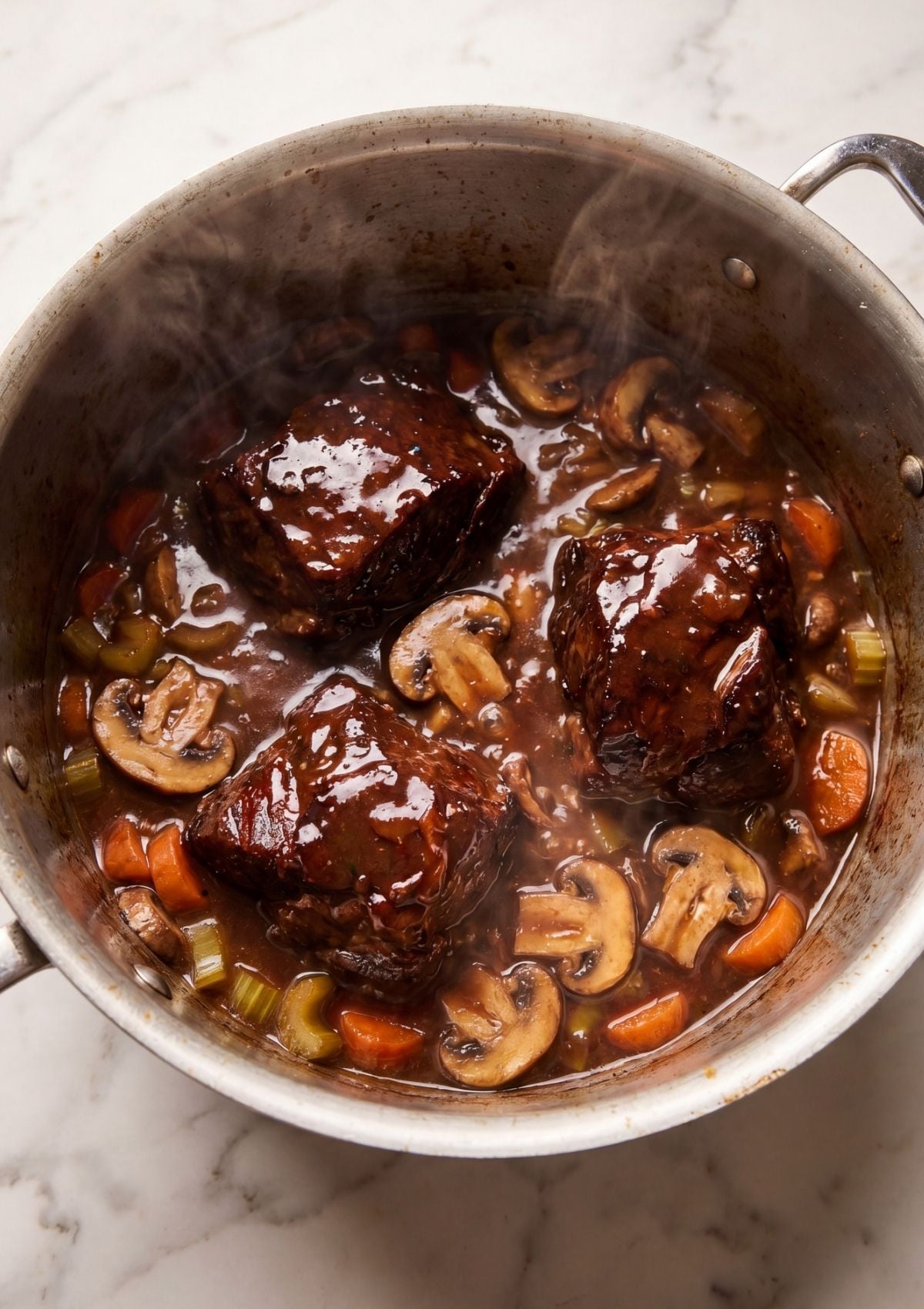 wagyu beef cheek recipe cooking in pot with mushrooms carrots and celery rich stew