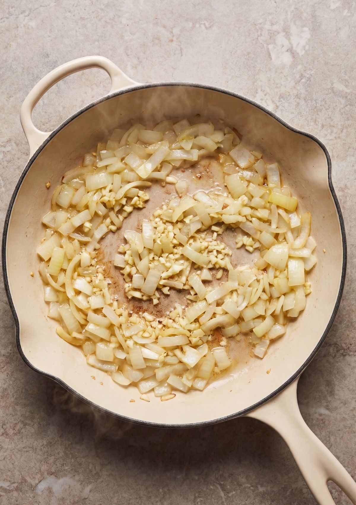 chopped onions and garlic cooking in skillet for cowboy spaghetti recipe base