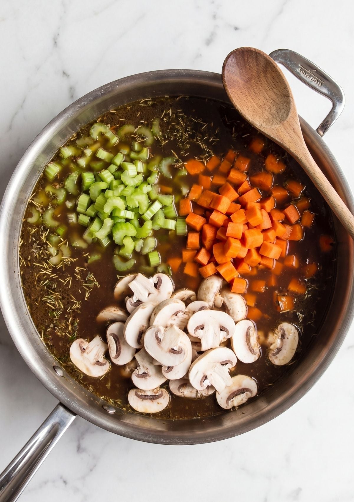 chopped carrots celery mushrooms added to broth for wagyu beef cheek recipe