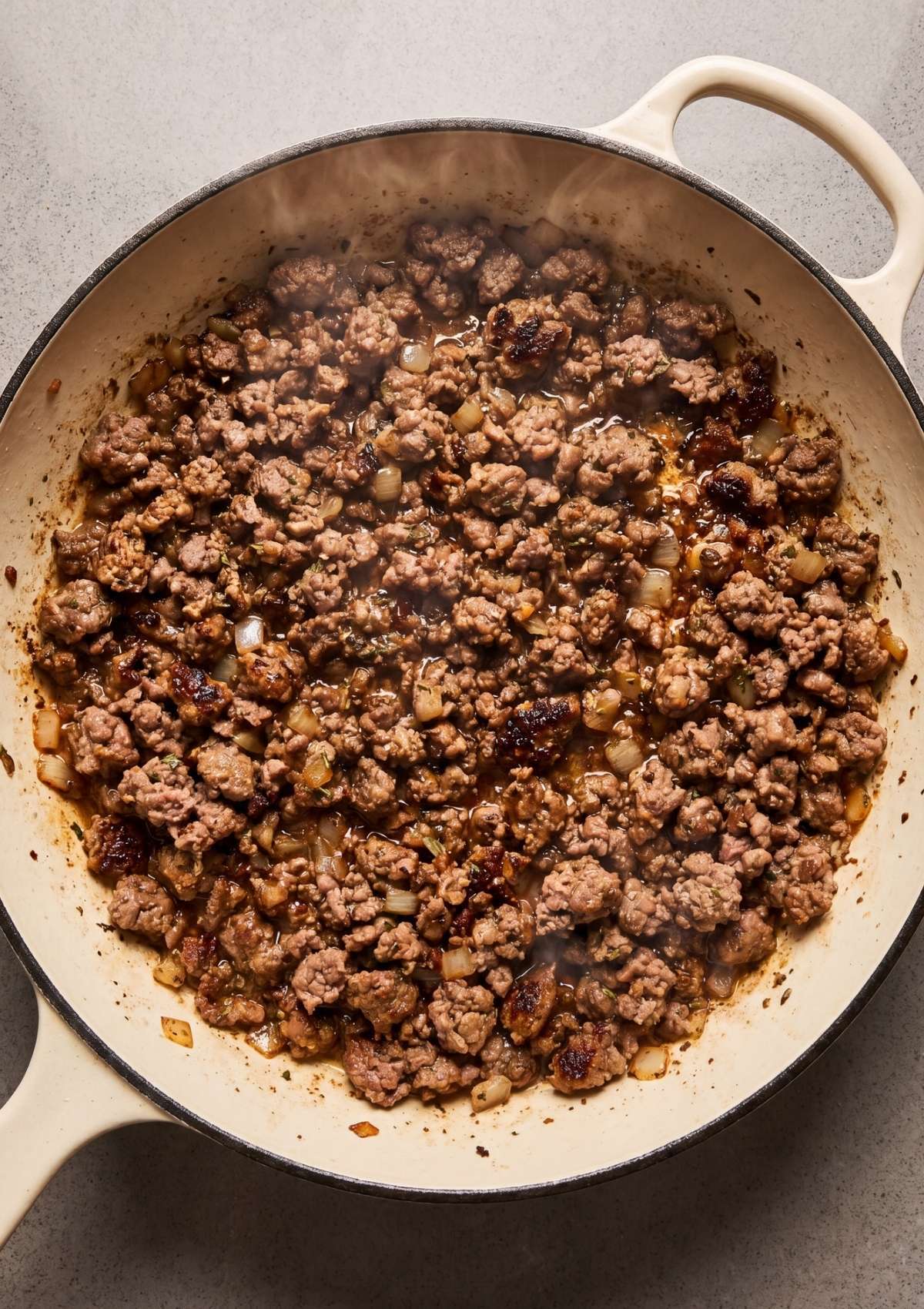 browned ground beef cooking in skillet for cowboy spaghetti recipe easy dinner