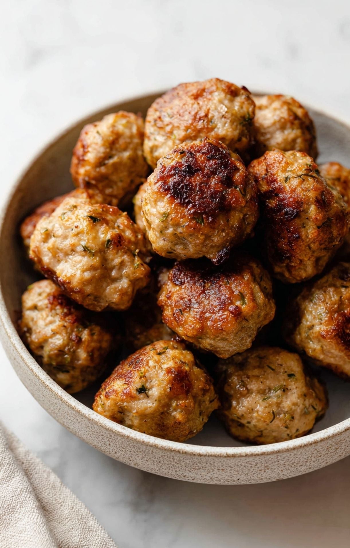 A bowl of golden-brown meatballs freshly cooked from frozen, showing the crispy exterior achieved with the frozen meatballs air fryer method.