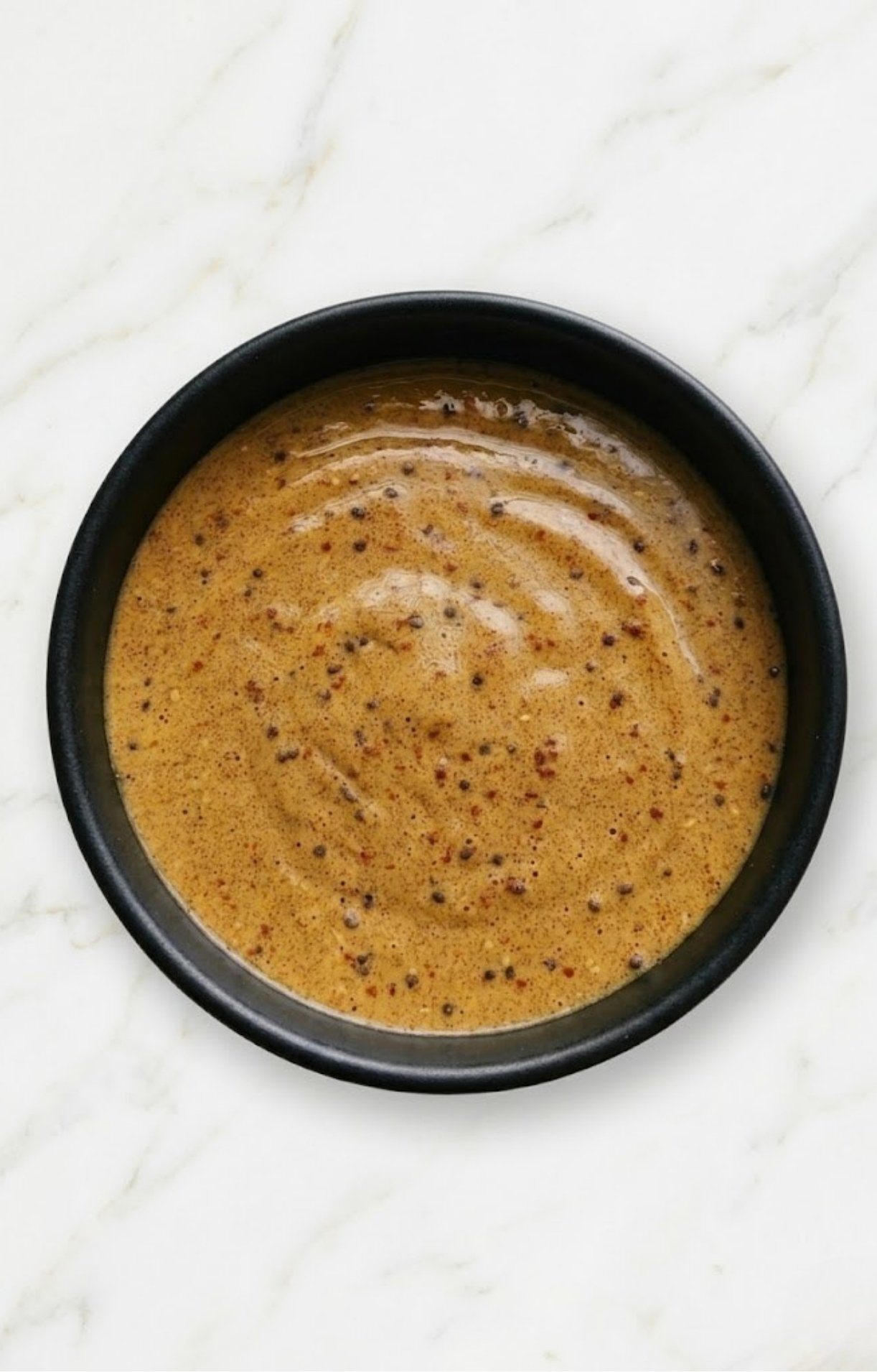 A top-down view of the fully blended steak salad dressing recipe in a dark bowl, ready to be served.