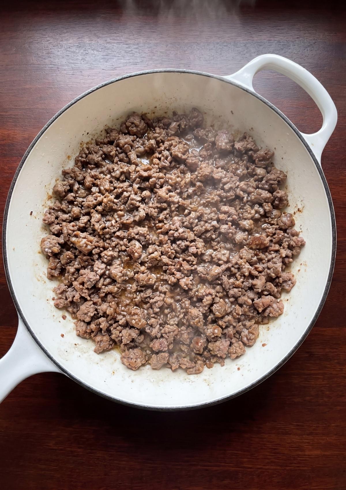 ground beef browning in skillet for one pot cowboy spaghetti easy dinner recipe
