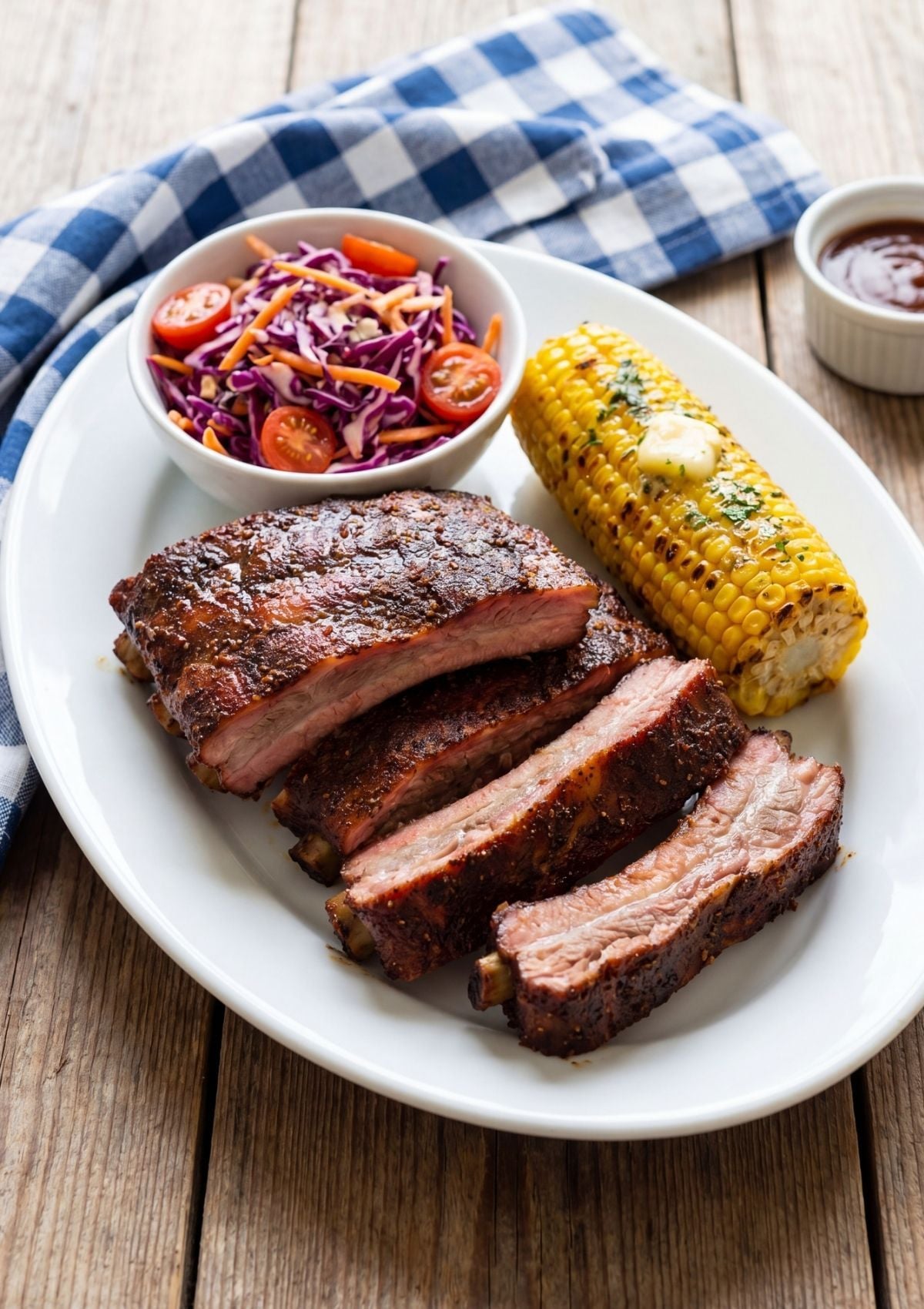 pellet smoker memphis ribs recipe served with corn on the cob and coleslaw on white plate