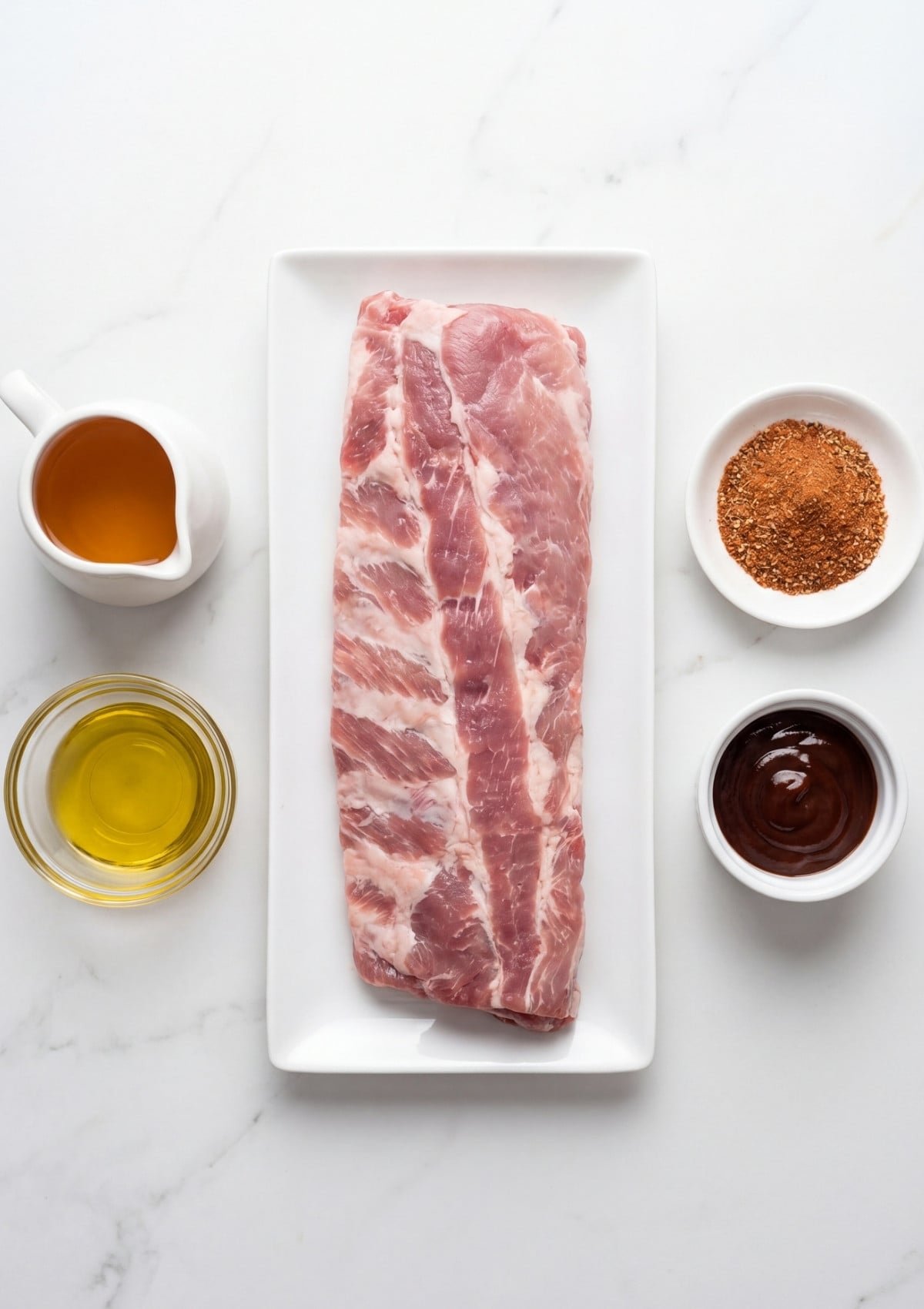 Pit Boss pellet smoker rib recipe ingredients with raw pork ribs olive oil BBQ sauce dry rub and apple juice ready for smoking