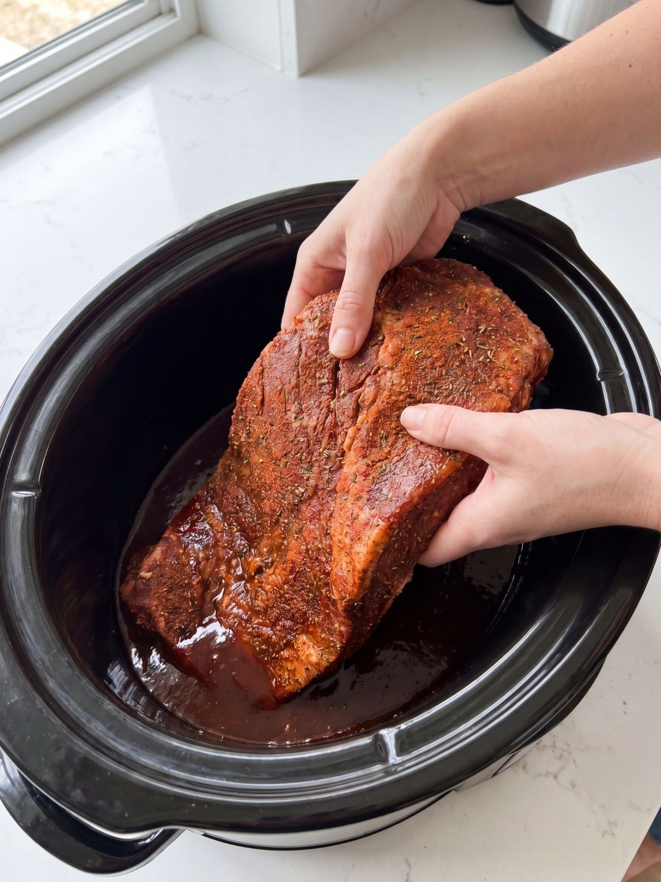 tender wagyu beef brisket recipe placing seasoned brisket into slow cooker with sauce