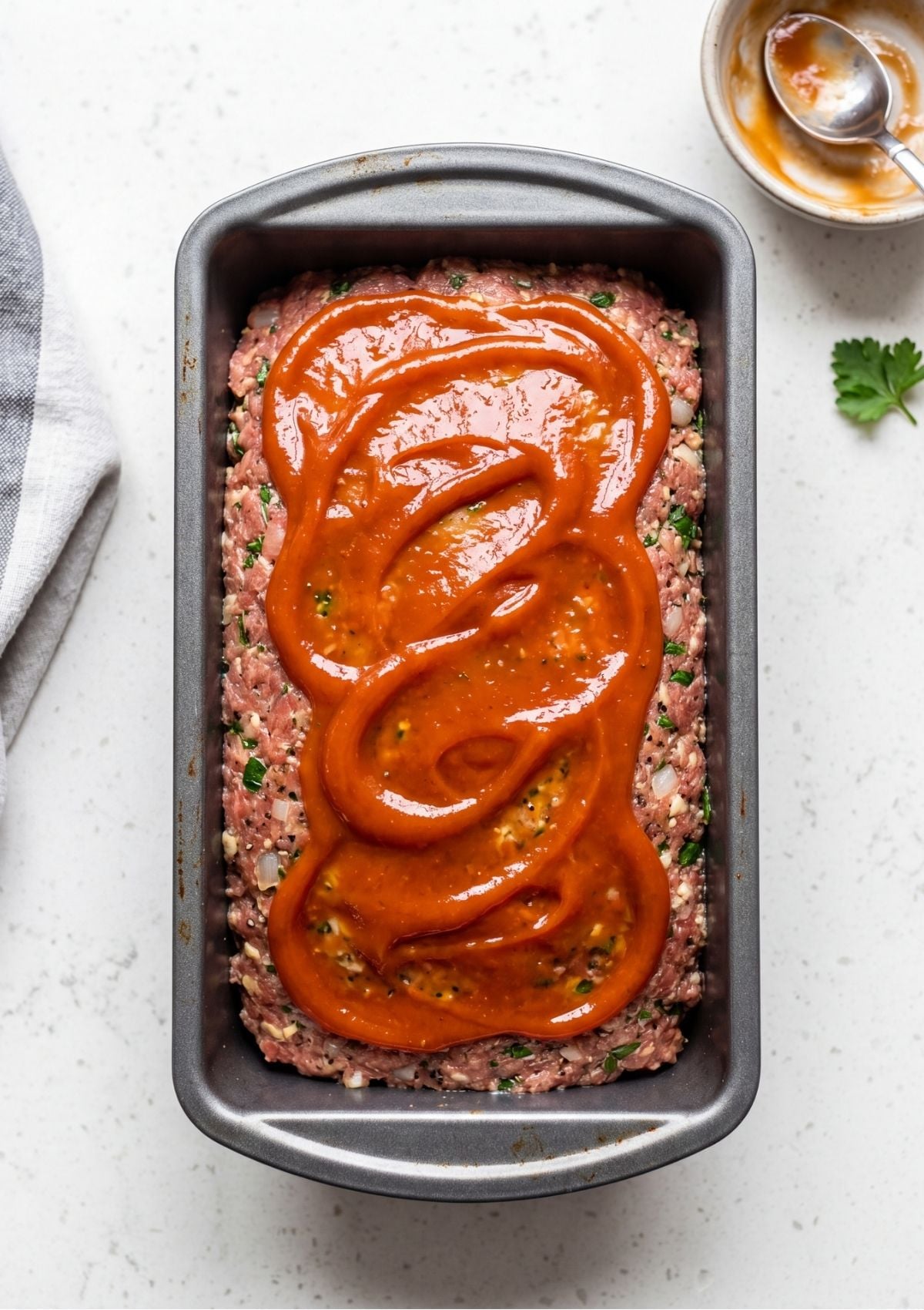 A small white bowl containing a mixture of ketchup, yellow mustard, and brown sugar for a Traditional Meatloaf Recipe.