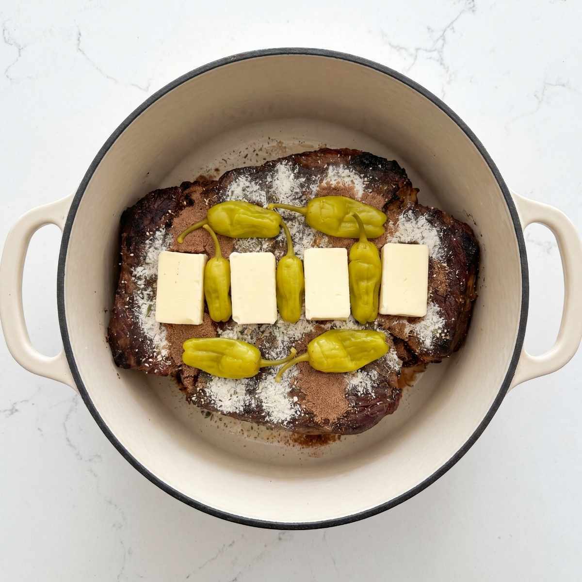 smoked-chuck-roast-in-a-dutch-oven-topped-with-ranch-au-jus-butter-and-pepperoncini